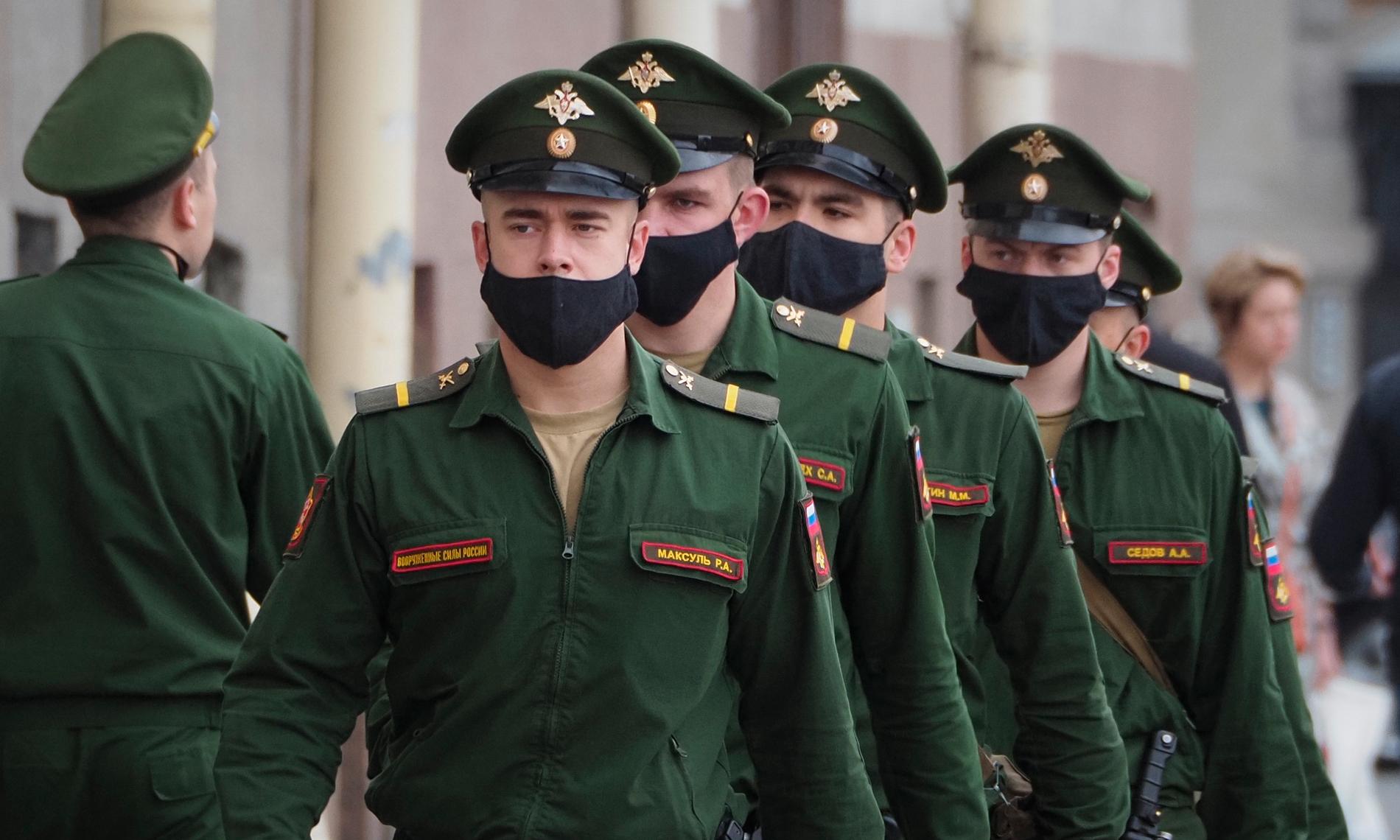 Soldater med ansiktsmasker marscherar i ryska S:t Petersburg. Landets dödstal är lågt i förhållande till antalet smittade.
