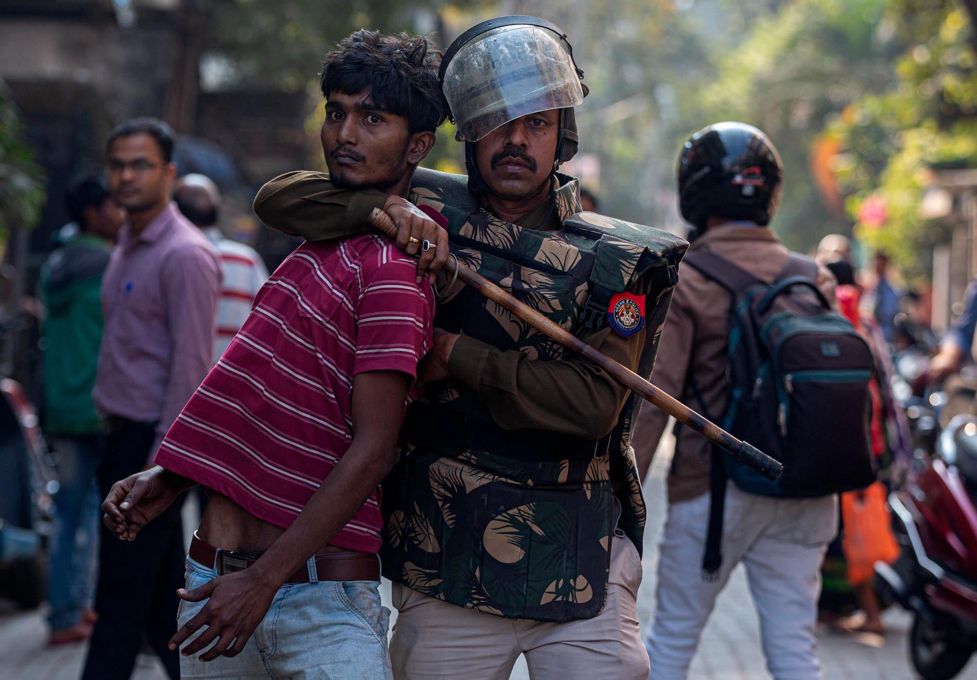 En polis håller fast en demonstrant vid protester i Gauhati på onsdagen. Protesterna riktas mot lagstiftning som kritiseras för att ytterligare marginalisera muslimer i Indien.
