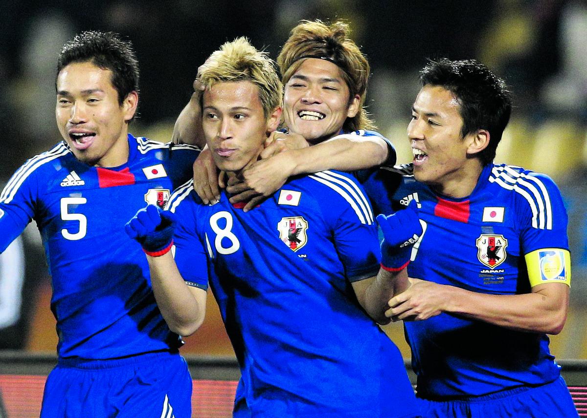 Keisuke Honda, i mitten, kramas om av sina lagkamrater i det japanska landslaget.