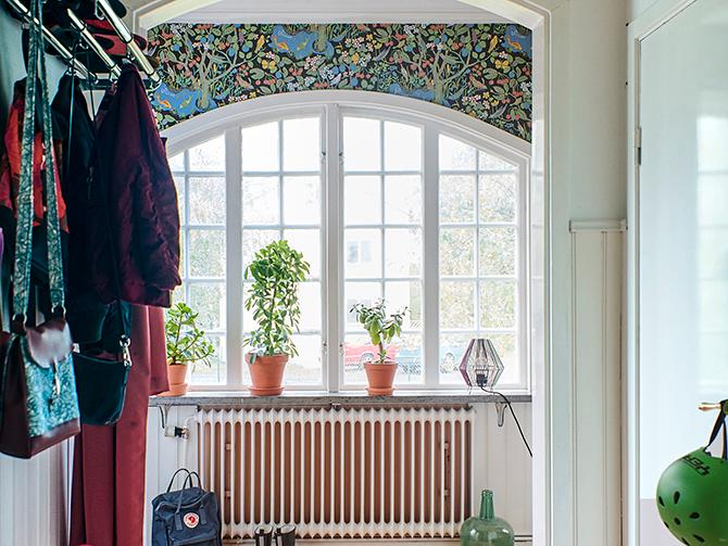 I hallen möts man av den färgglada tapeten ”Paradiset” av Josef Frank och vackra spröjsade fönster skapar ett extra varmt välkomnande.
