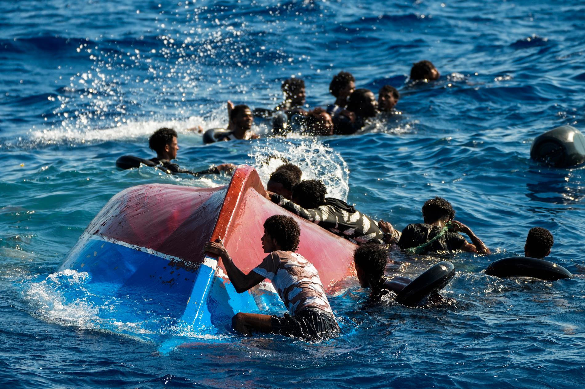 Flyktingar i havet utan för italienska ön Lampedusa efter att deras båt kapsejsat.