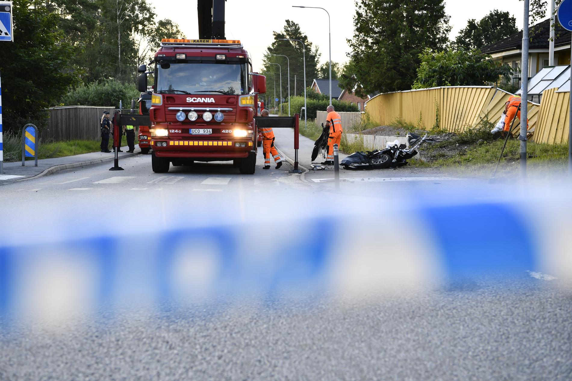 En person dog och två skadades då en polisbil under utryckning krockade med en mopedbil i Täby.