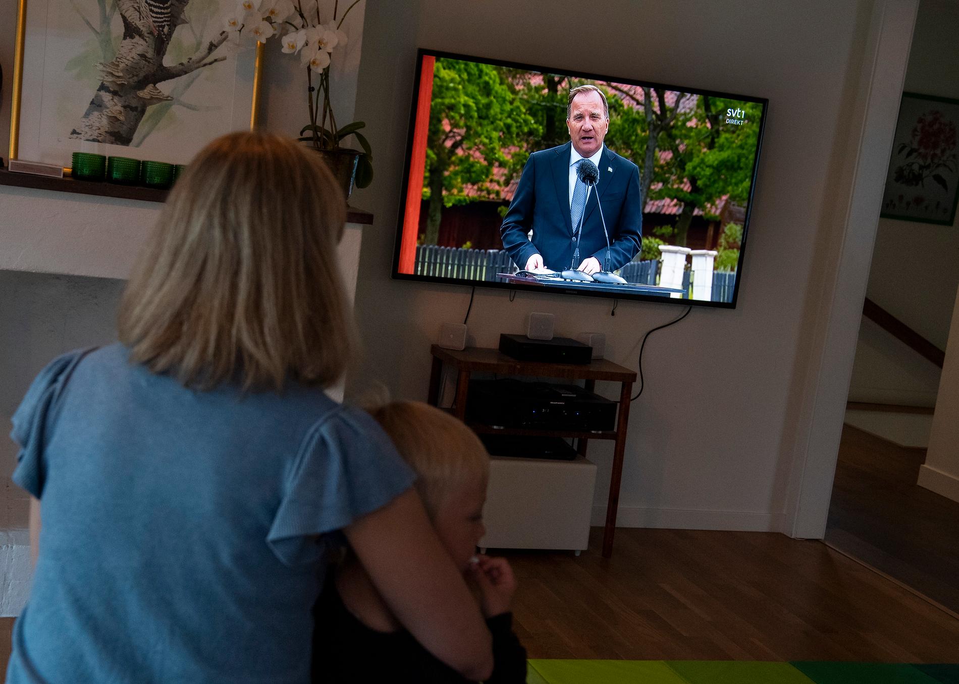 En familj tittar på Skansens tv-sända nationaldagsfirande med tal av statsminister Stefan Löfven (S).