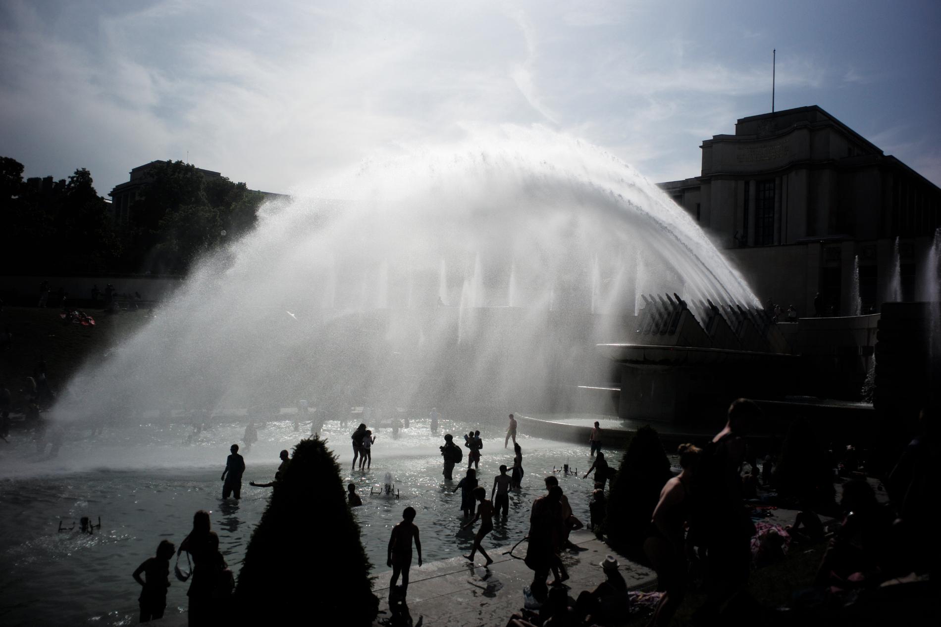 Människor svalkar sig i fontänen i Trocaderoträdgården i Paris den 28 juni, då värmen senast slog till i huvudstaden.
