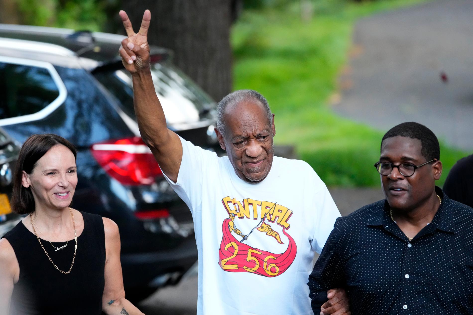 Bill Cosby gjorde segertecken utanför sitt hem efter att ha släppts ur fängelset. Skådespelarens publicist Andrew Wyatt till höger.