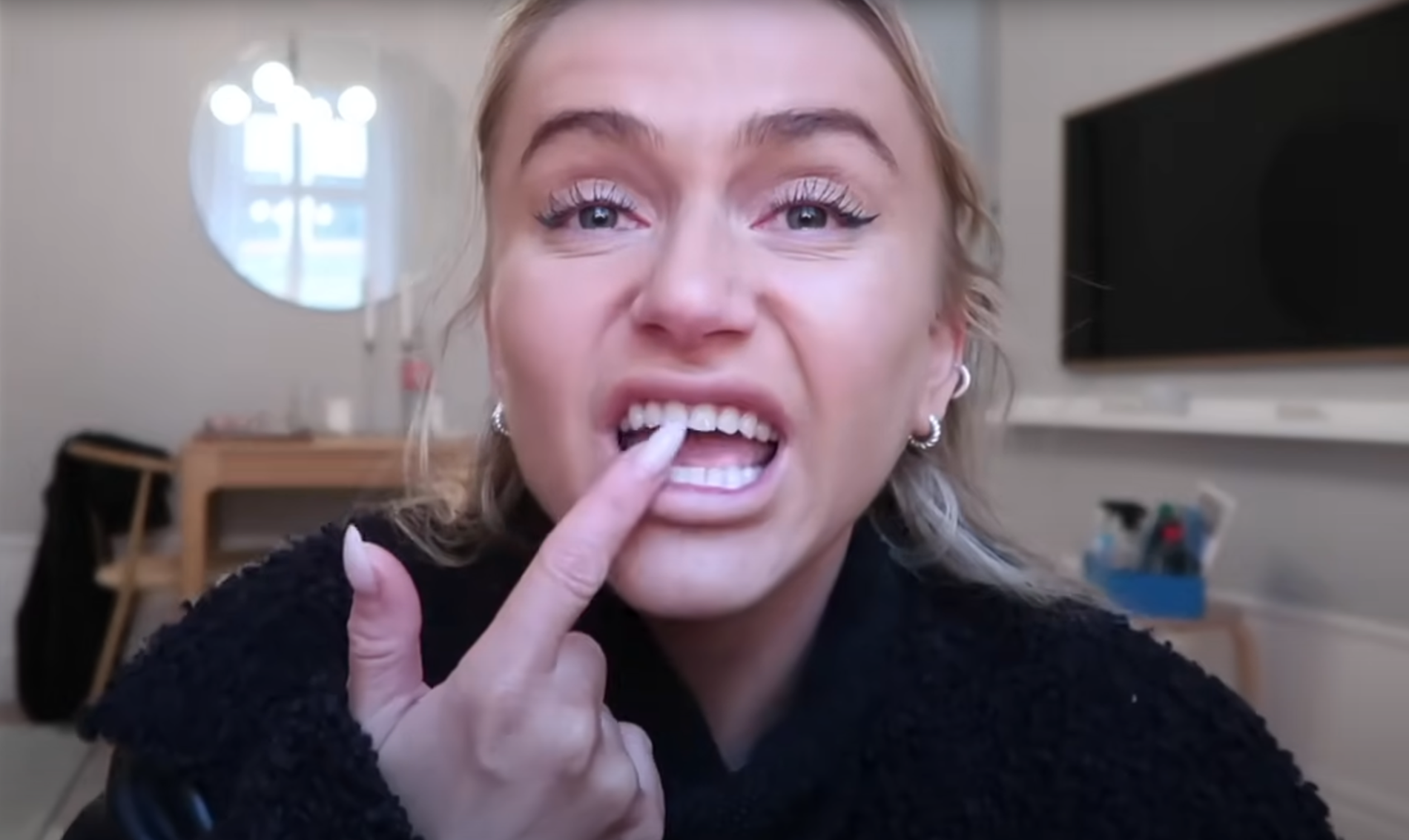 Influencern visar upp tänderna i video.