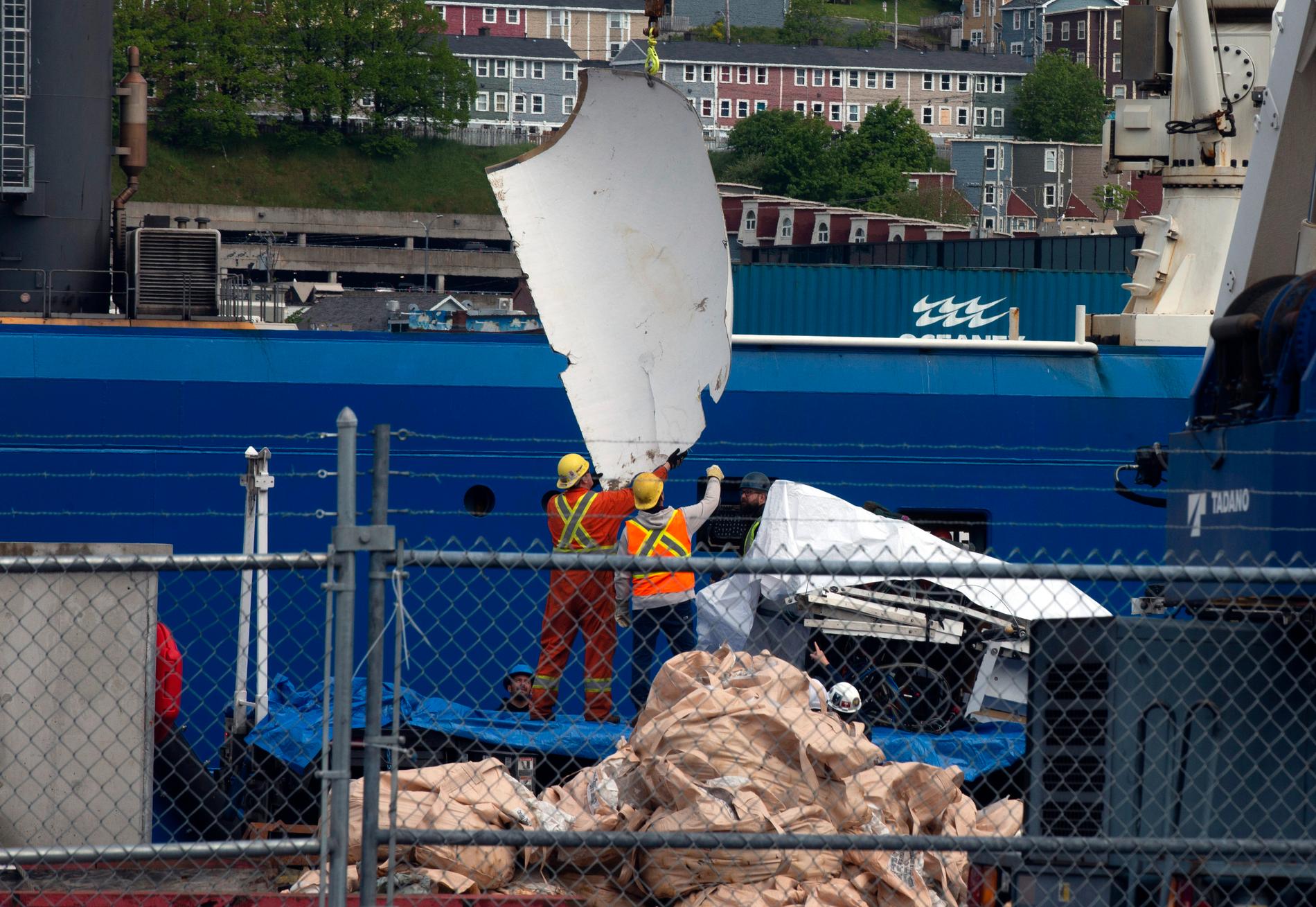 Bärgade vrakdelar från miniubåten Titan, som förliste utanför Newfoundland, lastas av i hamnen St. John's den 28 juni.