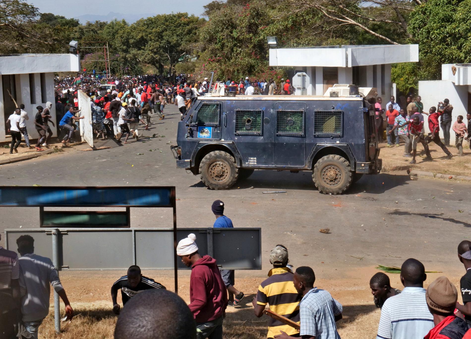 Demonstranter som protesterar mot valet i maj kastar sten mot ett polisfordon i Malawis huvudstad Lilongwe den 20 juni.