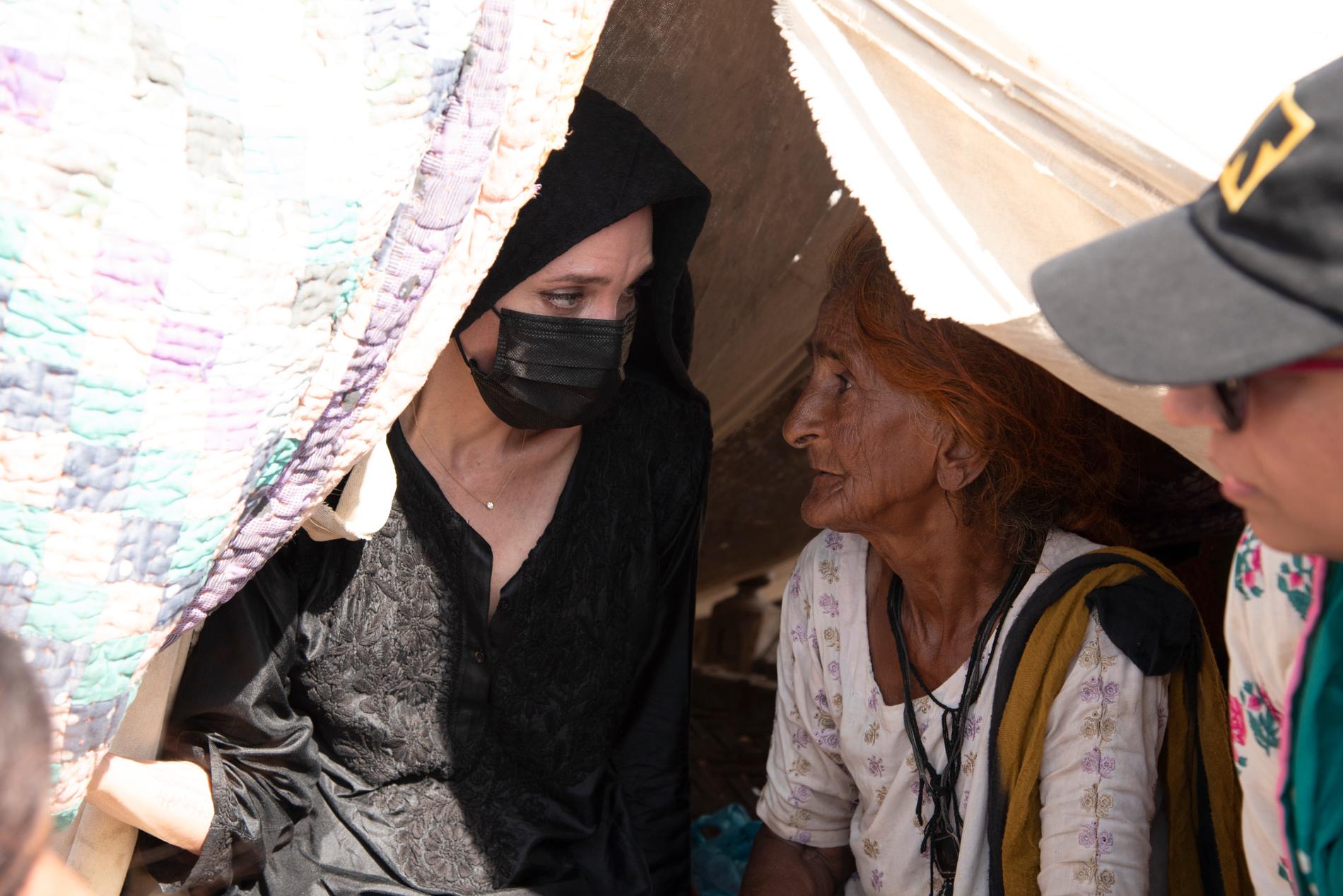 Angelina Jolie besöker en äldre kvinna som bor i ett provisoriskt tält. Hon har liksom miljontals andra förlorat sitt hem i översvämningen. Hon har haft konstant feber de senaste dagarna och tältet ger inget skydd mot väder och vind.