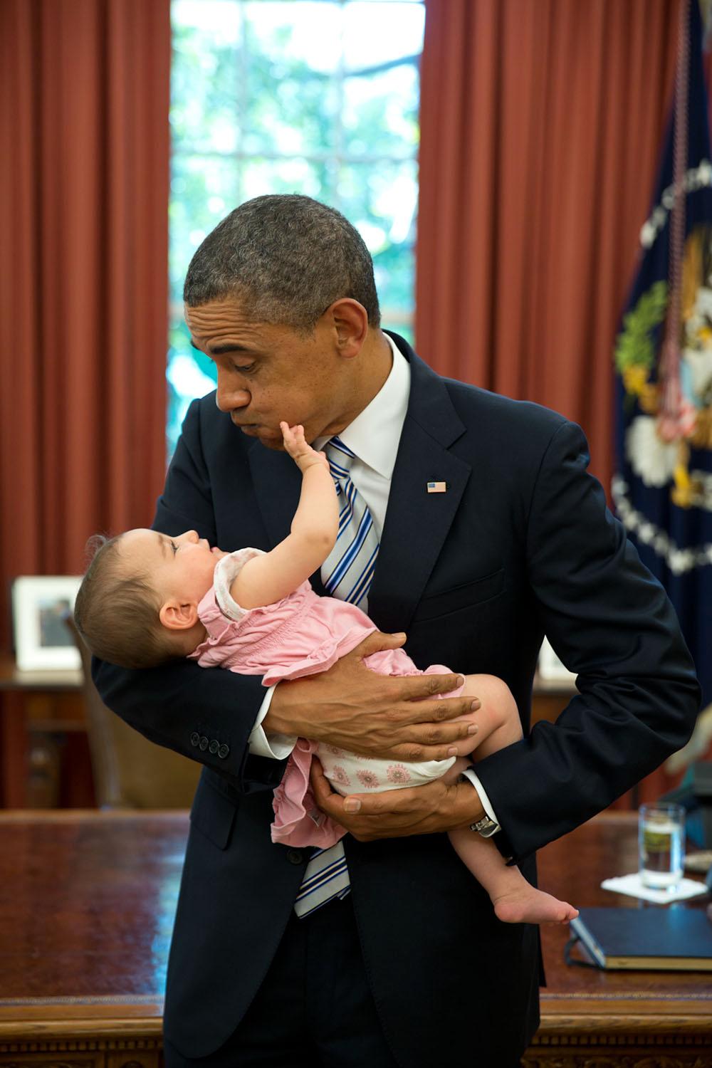 En medarbetares bebis får tag på presidentens ansikte.