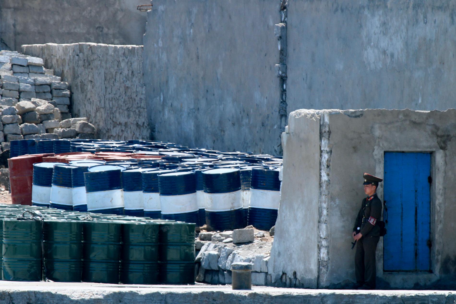 En nordkoreansk soldat vaktar oljetunnor i staden Sinuiju nära gränsen mot Kina. Arkivbild.