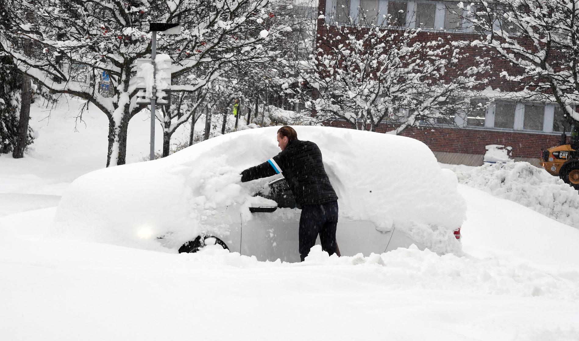 En man skottar fram sin bil efter att det fallit 39 cm snö på ett dygn. Stockholm 2016