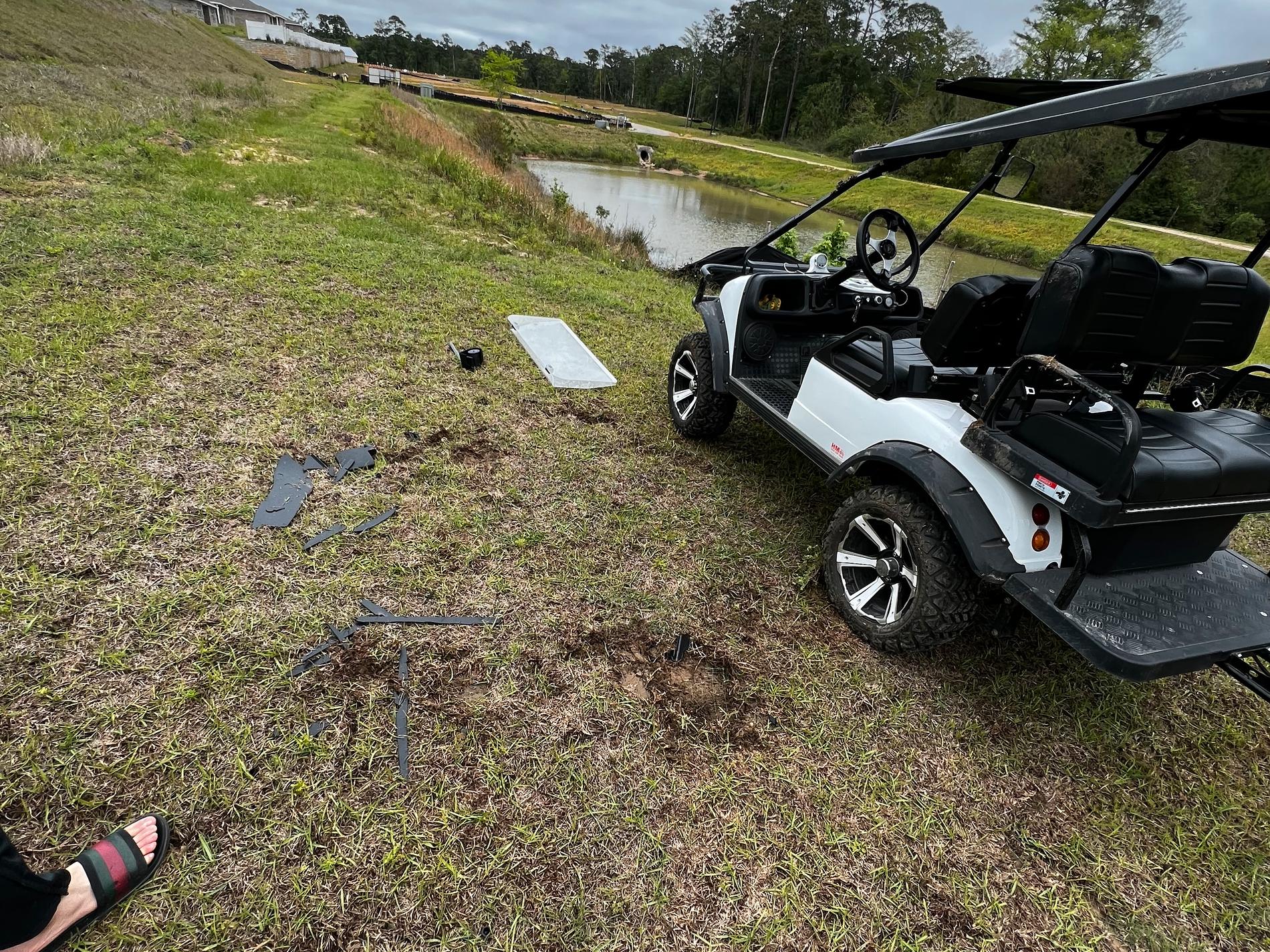 Rester av golfbil på marken efter kraschen.