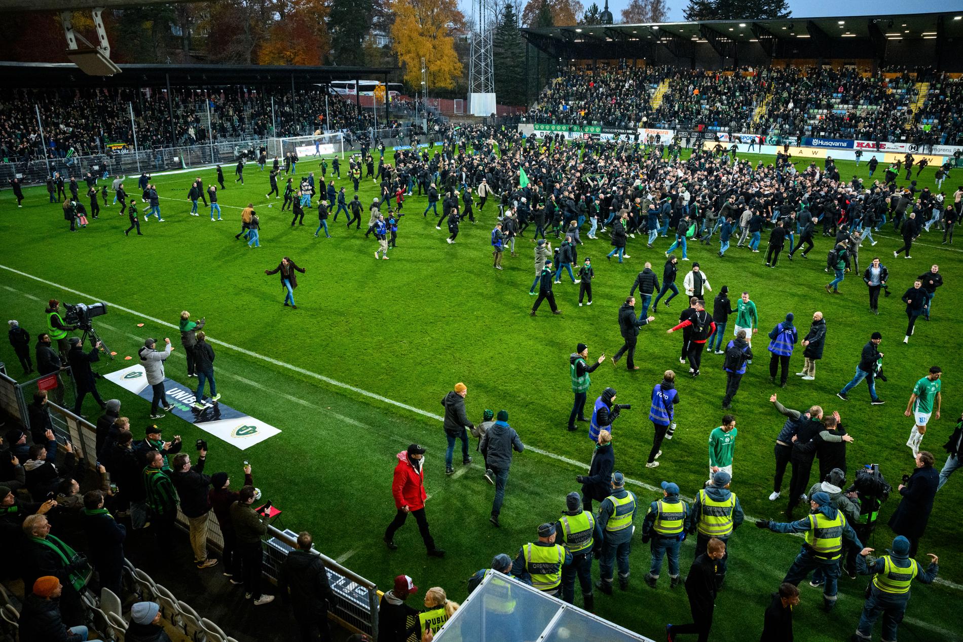 Gais fans stormar planen i Jönköping efter avancemanget till allsvenskan.