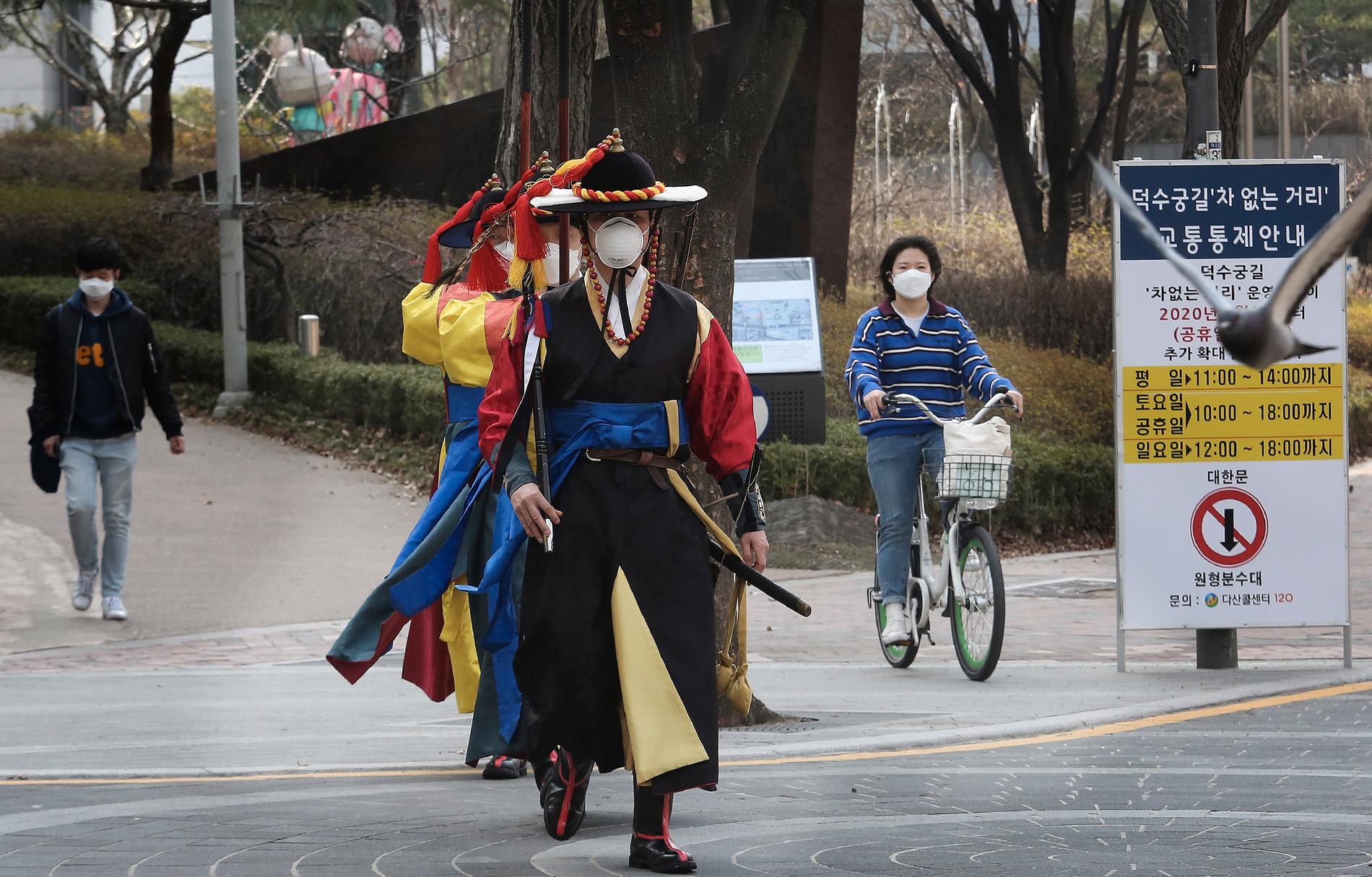 SEOUL, SYDKOREA Vakt vid palatset Deoksu gör som andra och använder munskydd på väg till jobbet i Seoul på lördagen.