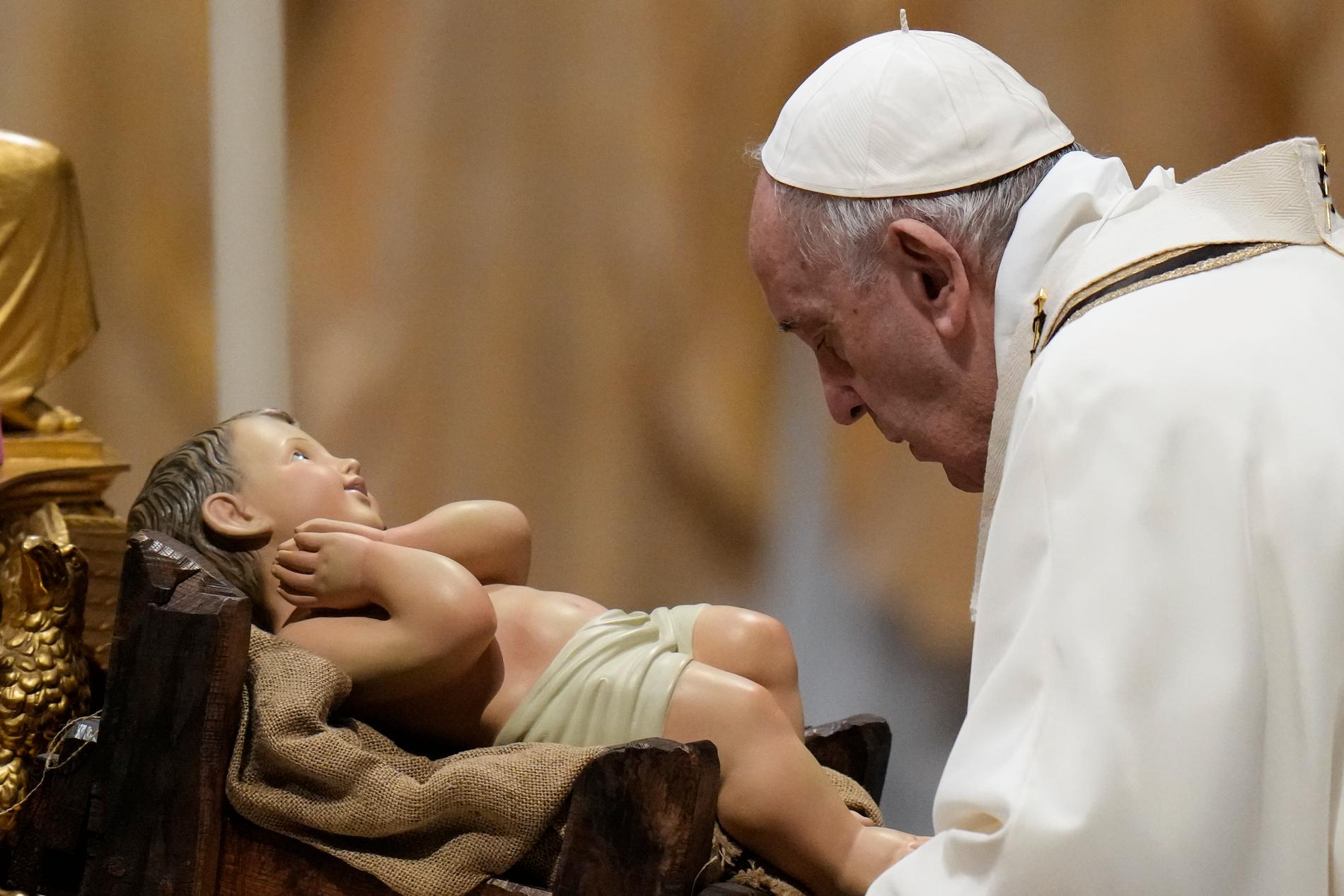 Påve Franciskus vid en staty av Jesusbarnet i Peterskyrkan i Rom, julafton 2013. 