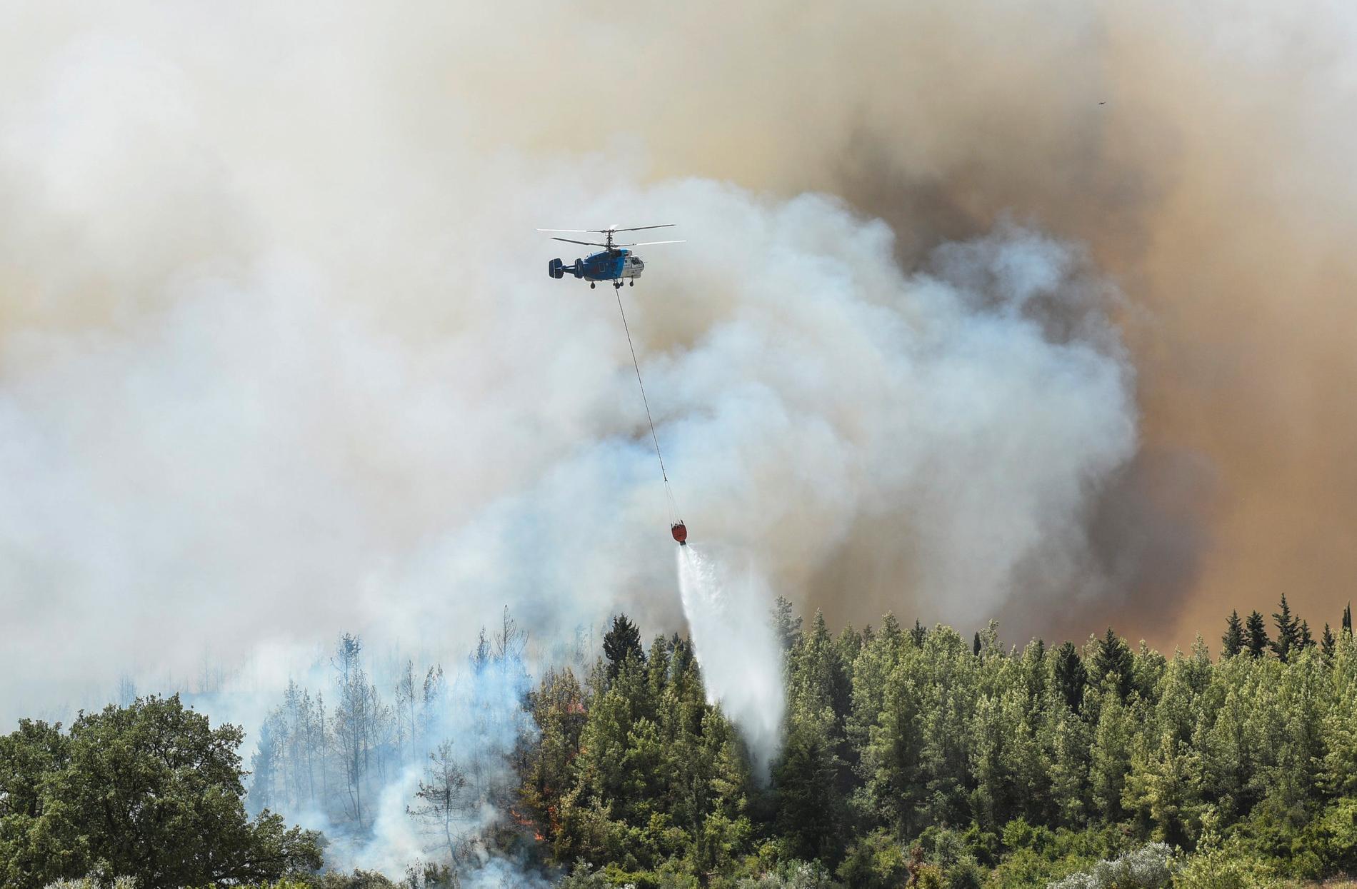 En helikopter vattenbombar en brand utanför Antalya på lördagen.
