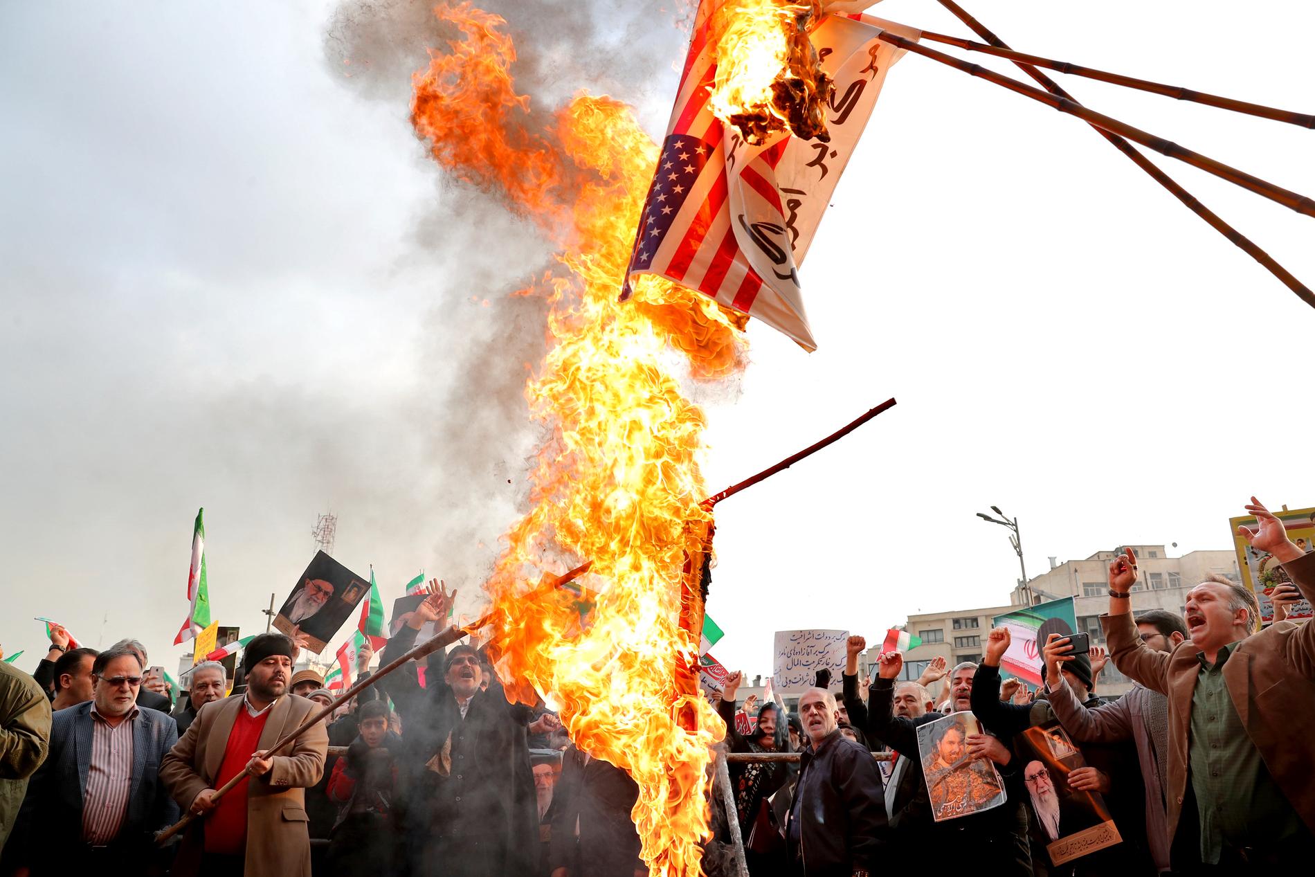 Demonstranter bränner en avbildning av den amerikanska flaggan.