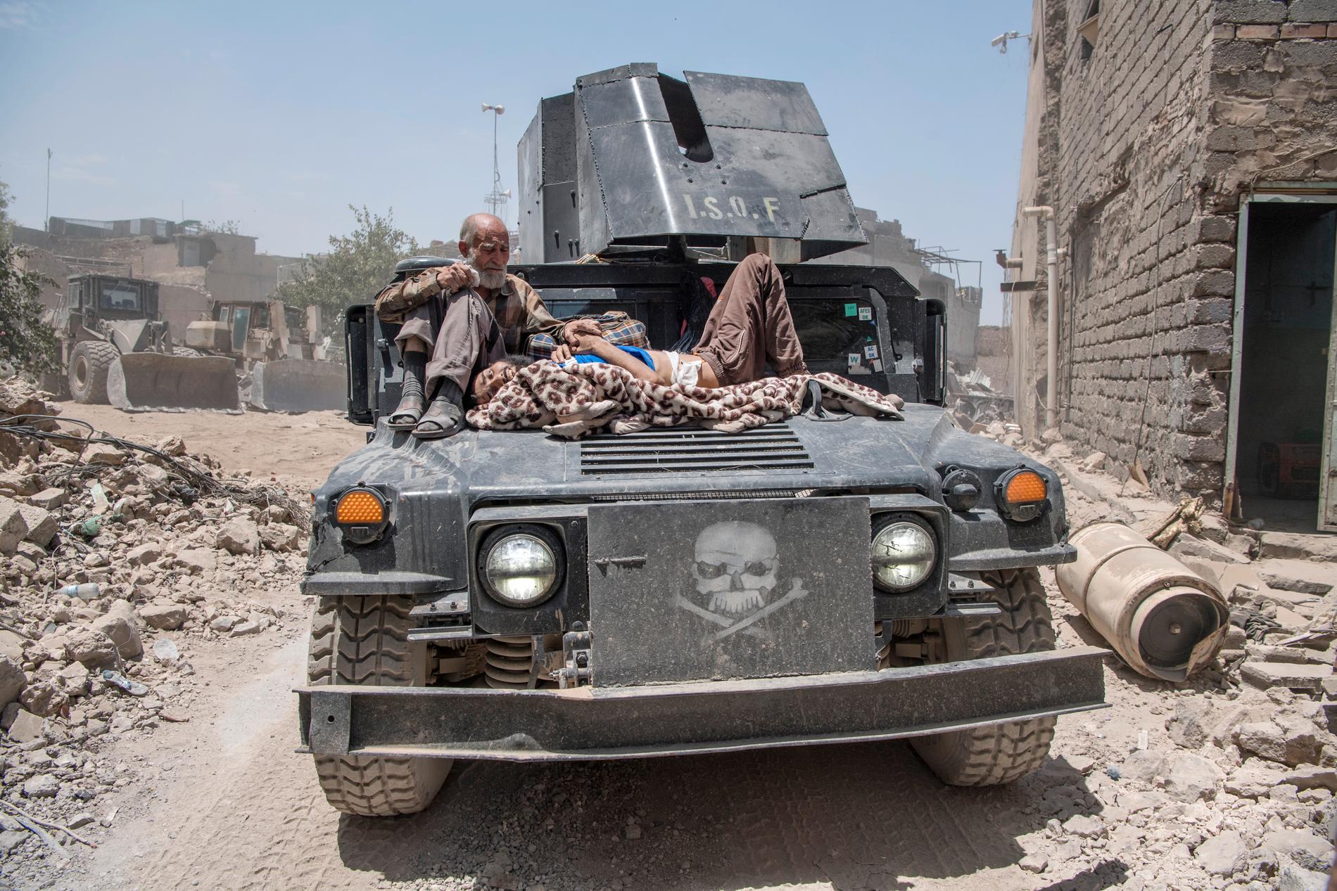 Människor som flyr ut ur Mosuls gamla stad får skjuts av irakiska styrkor.