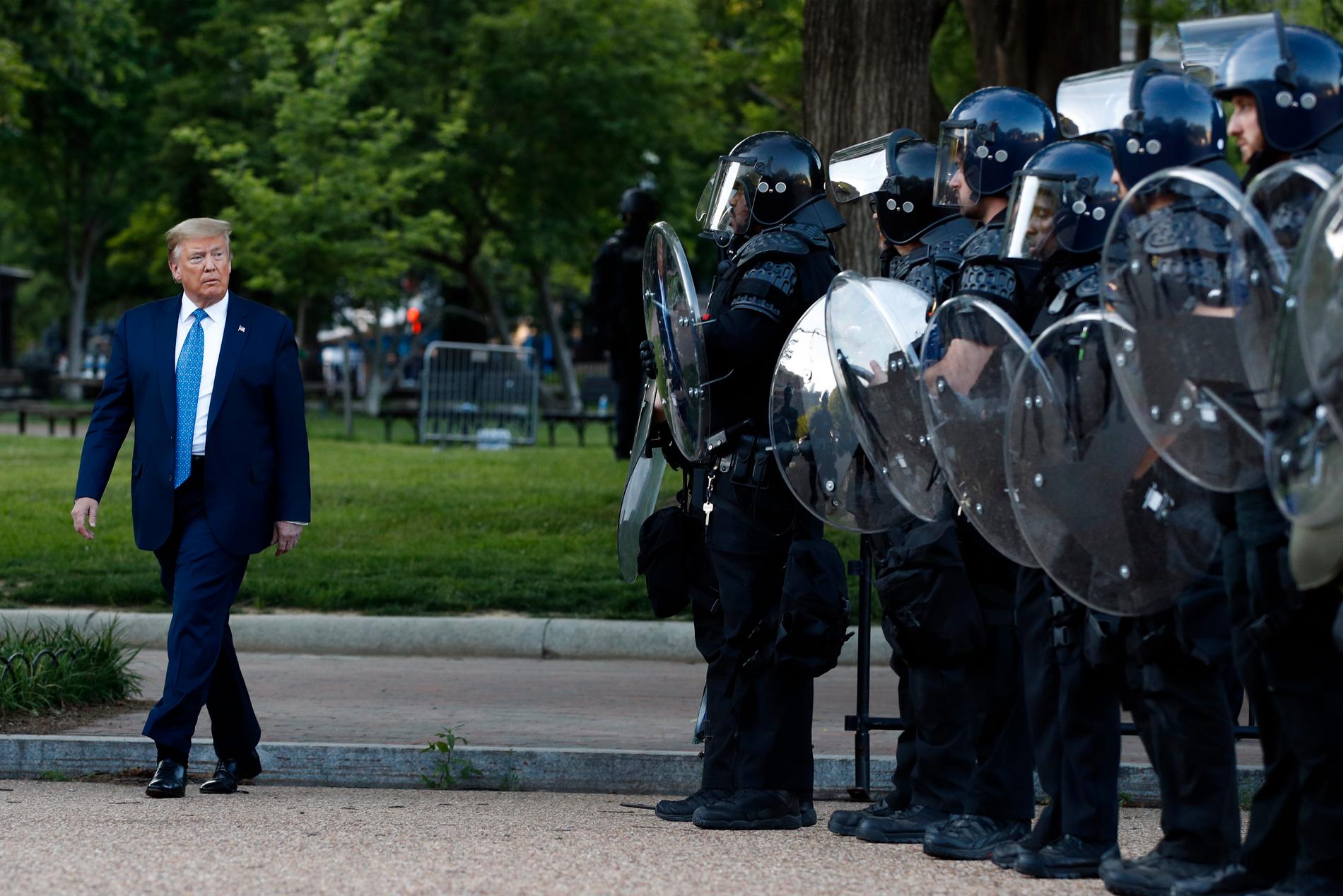 President Donald Trump passerar kravallutrustad polis i Lafayetteparken bredvid Vita huset.