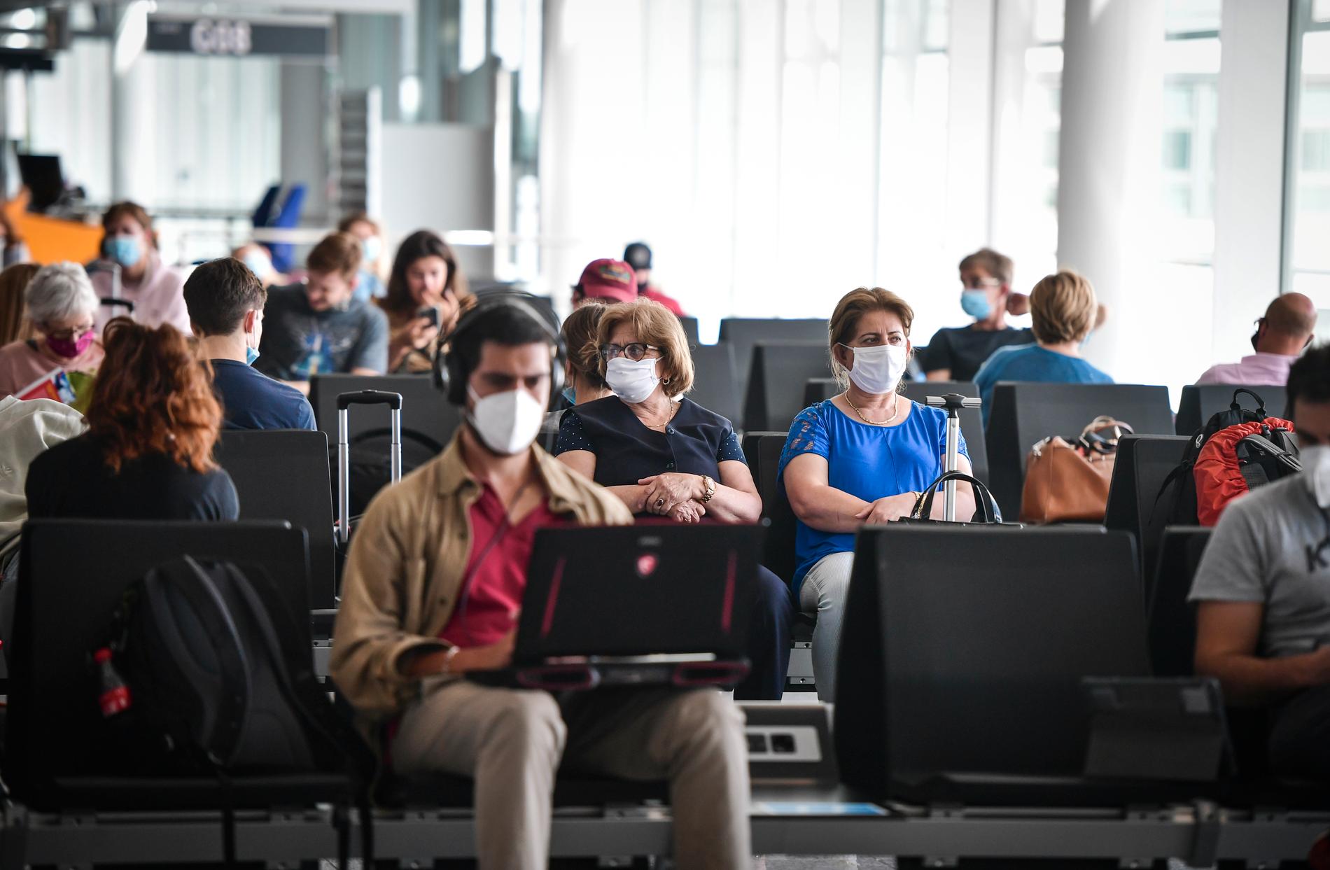Resenärer med munskydd på Münchens flygplats.