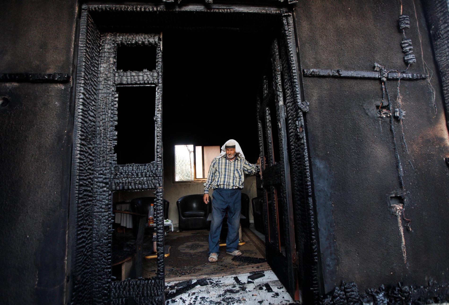 En man tittar på huset som brändes ned i attacken i juli 2015. Arkivbild.