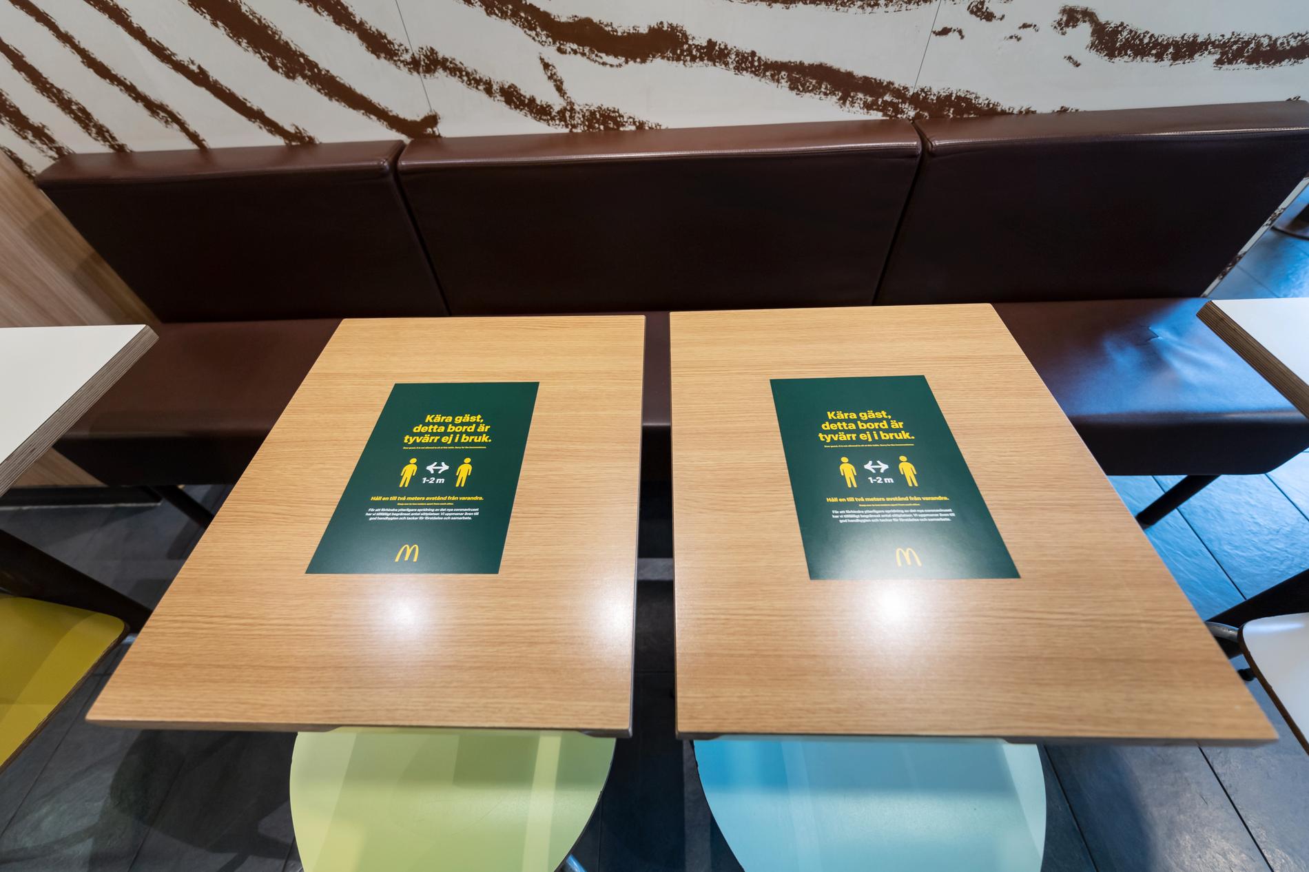 Dekaler på borden med texten "Kära gäst, detta bord är tyvärr inte i bruk" informerar McDonalds gäster om att hålla avstånden till varandra.