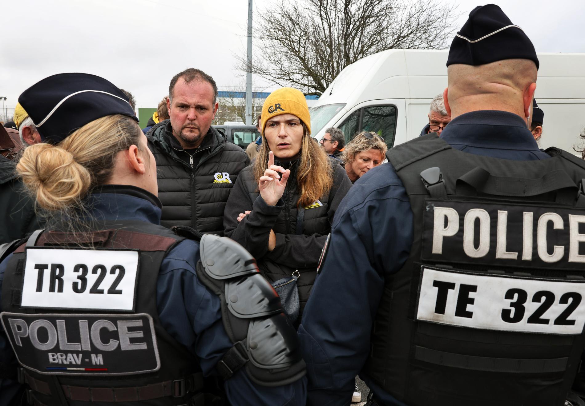 Aktivisten Karine Duc argumenterar med kravallpolisen.
