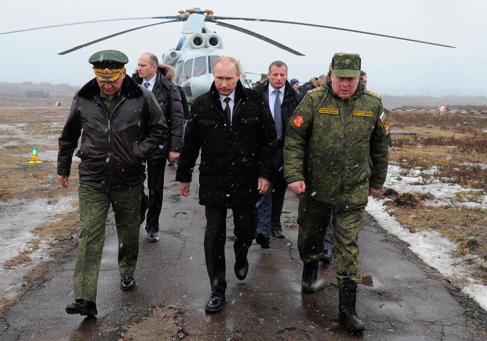 Vladimir Putin, i mitten, flankerad av försvarsministern Sergei Shoigu (till vänster) och toppmilitären Anatoly Sidorov under en militärövning i St.Petersburg.