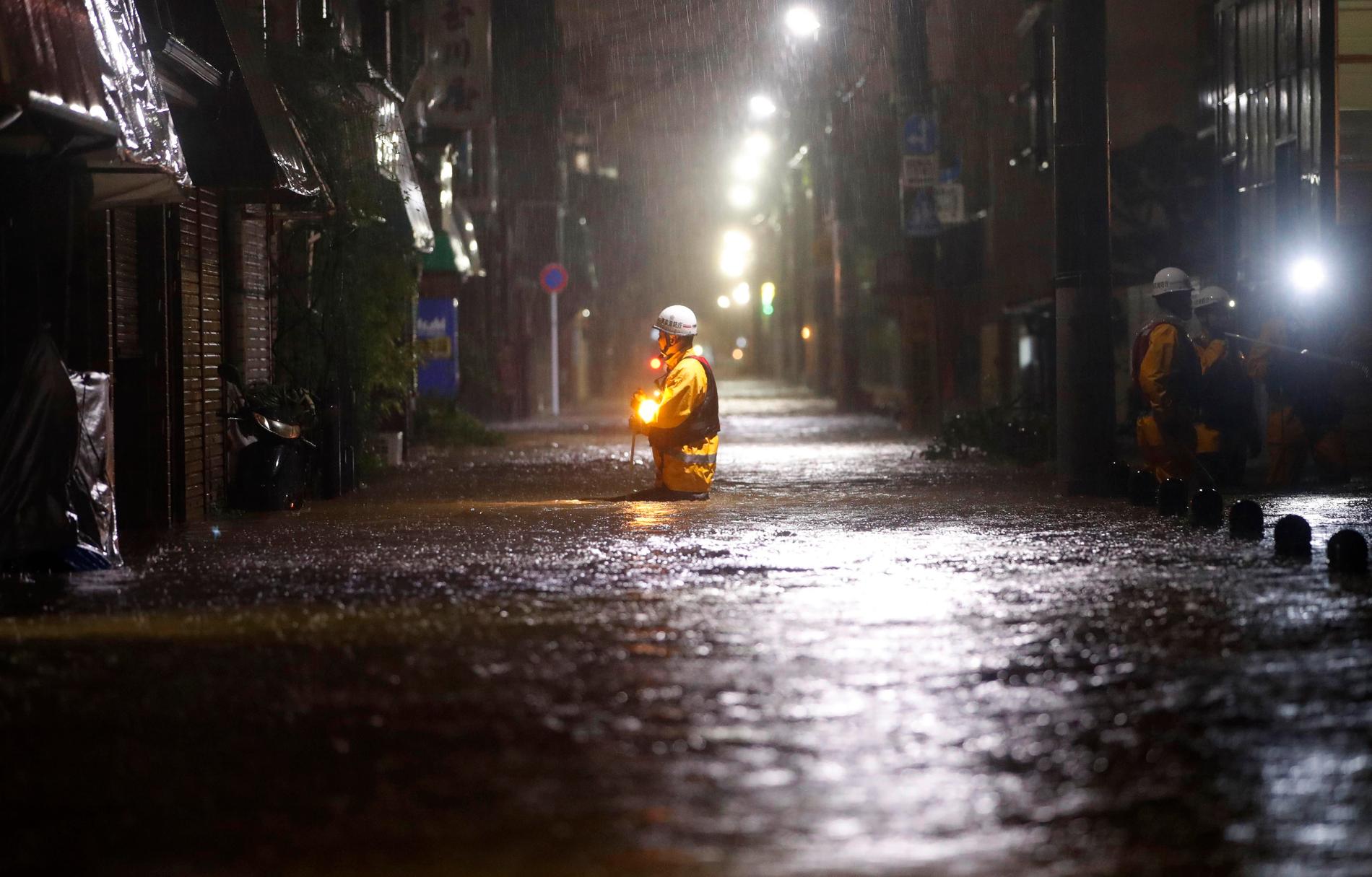 En brandman i en översvämmad gata i Tokyo.