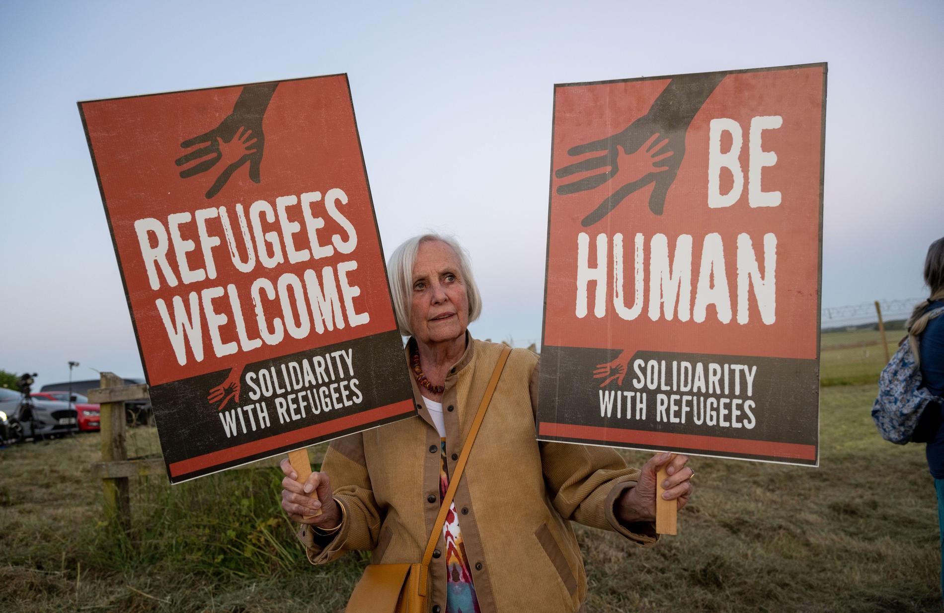En kvinna protesterar mot Storbritanniens nya asylpolitik. 