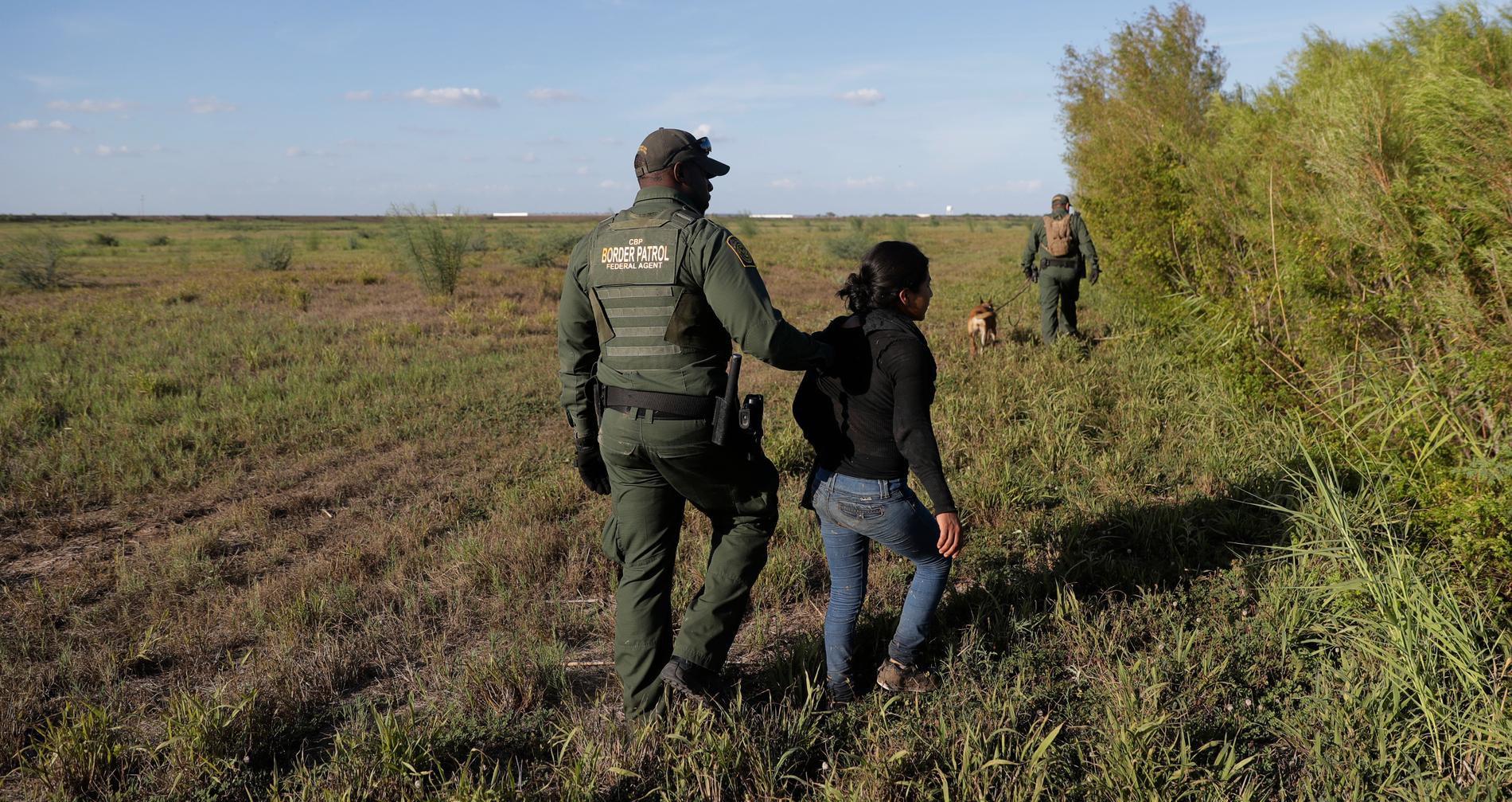 En gränsvakt i Texas med en person som gripits som misstänkt för att olagligt försökt ta sig över gränsen till USA.