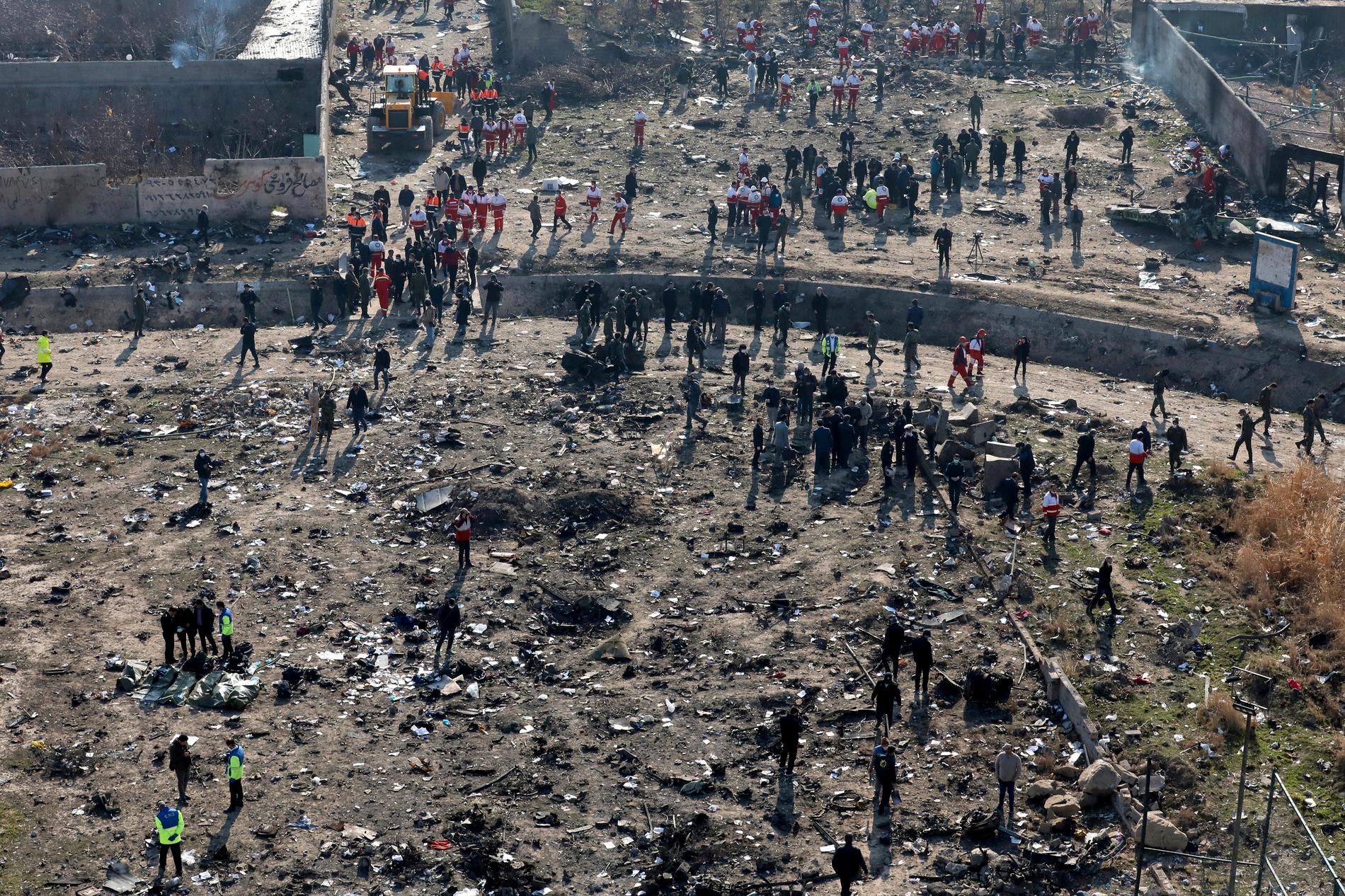 Räddningsarbetare söker på platsen där det ukrainska planet kraschade i Shahedshahr i Iran.