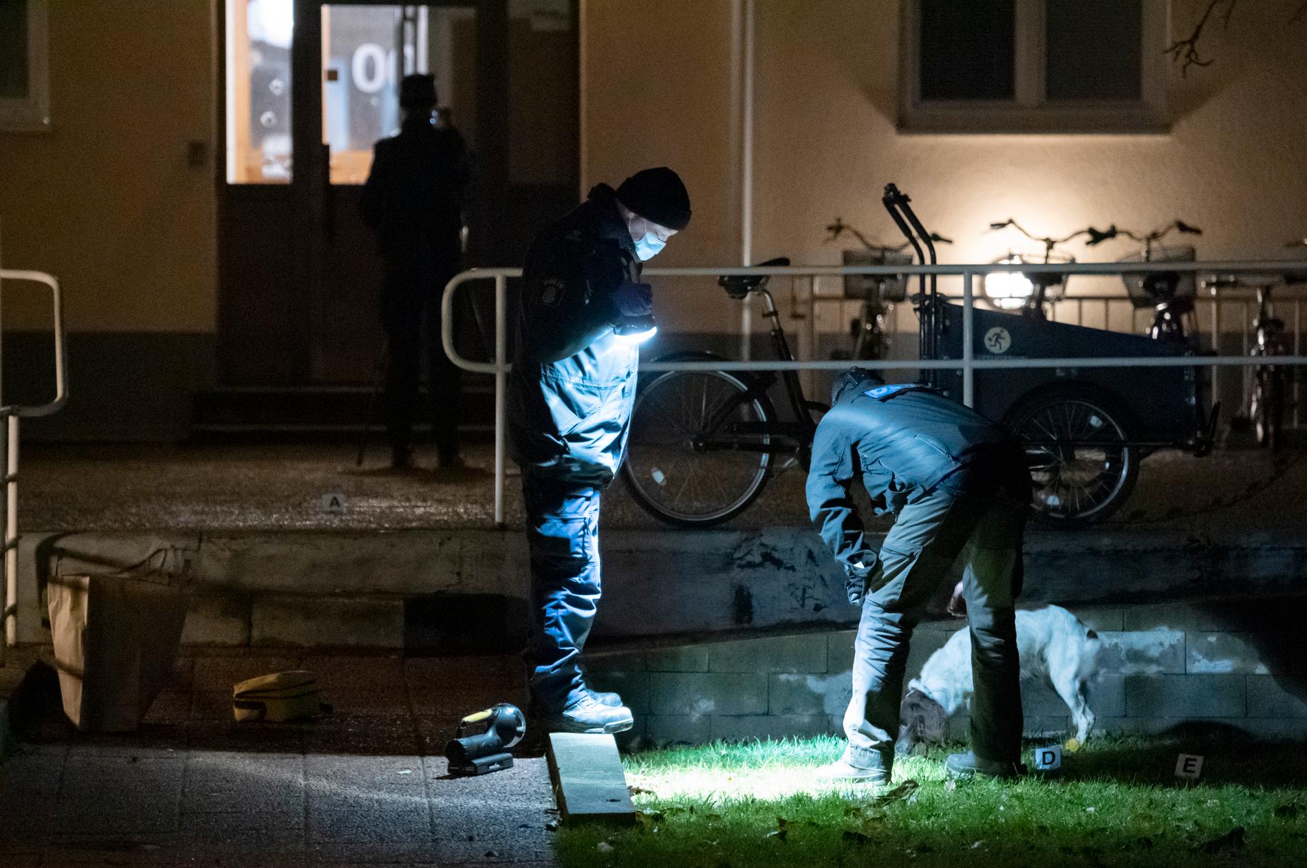 Polisens kriminaltekniker undersöker området vid en entrédörr till en flerfamiljsfastighet vid Fridhemstorget i centrala Malmö efter en skottlossning tidigt på lördagsmorgonen.
