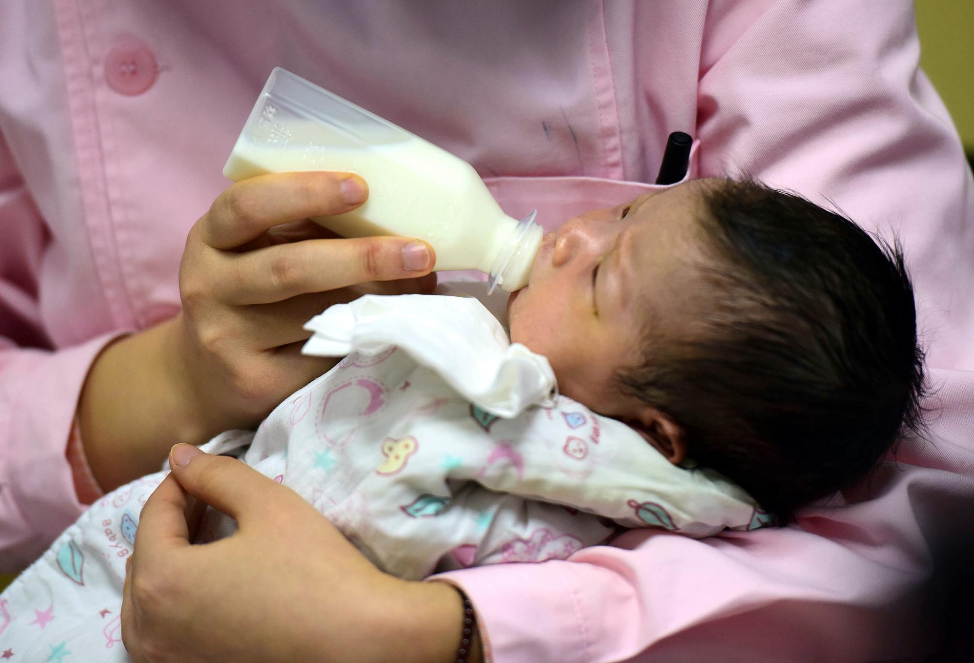 En nyfödd flaskmatas av en sköterska i den kinesiska staden Fuyang. Arkivbild.
