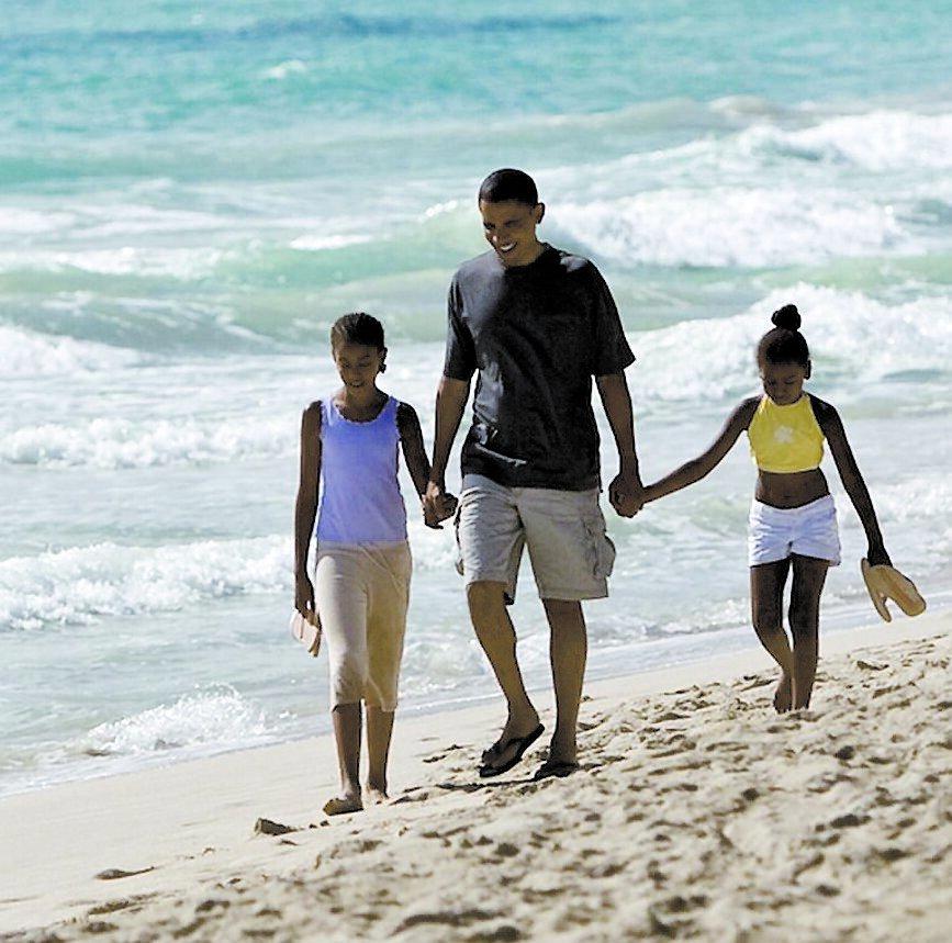 Barack Obama promenerar med sina döttrar på favoritstranden Kailua.