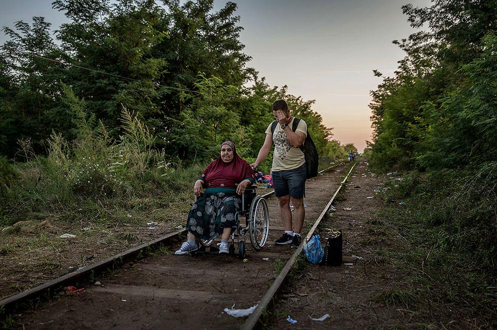 Bushra är sjuk och rullstolsbunden. Hennes son Ali Hussein är tvungen att köra henne i en rullstol över sylarna på järnvägen.
