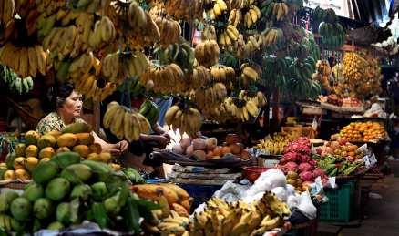 På marknaden hänger frukt i massor likt stora draperier.