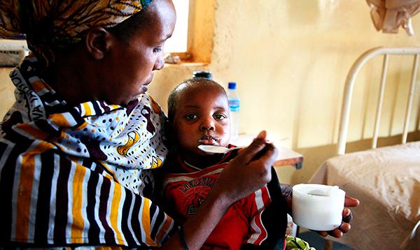 En kvinna i Tanzania med sin malariasjuka dotter på ett sjukhus som bedrivs med hjälp av svenskt bistånd. Det är lätt att plocka pengar från världens fattiga, skriver debattören.
