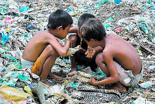 MISÄR I utkanten av landets huvudstad Rangoon sitter barn och äter mitt i en sophög.