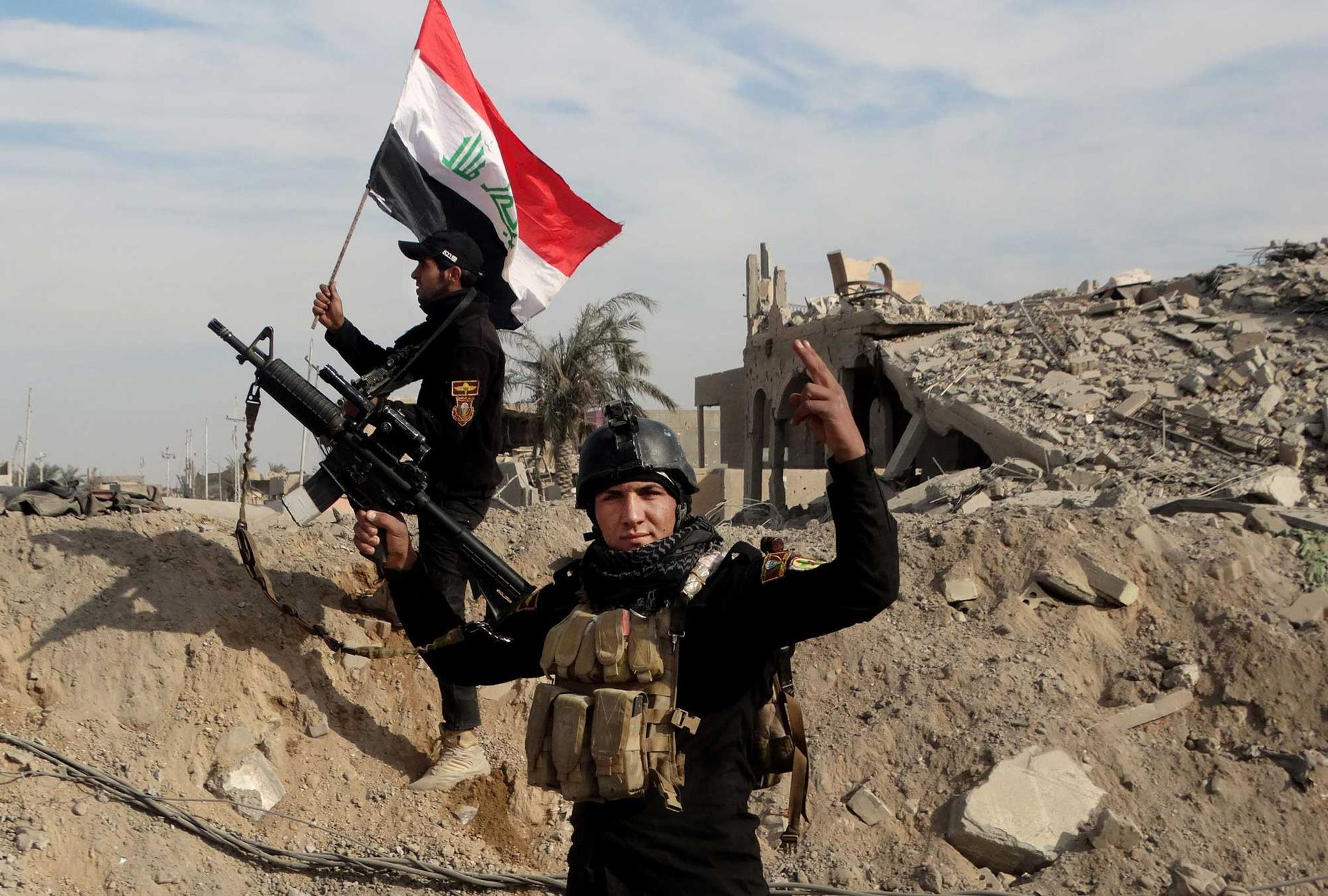 Bilden från söndagen 27 december visar irakiska styrkor hissa den irakiska flaggan i närheten av en jimmunal byggnad i centrala Ramadi drygt tio mil väster om Bagdad efter att man återtagit kontrollen över en strategisk regeringsbyggnad. Islamiska staten hade innan dess ockuperat staden sedan i maj.