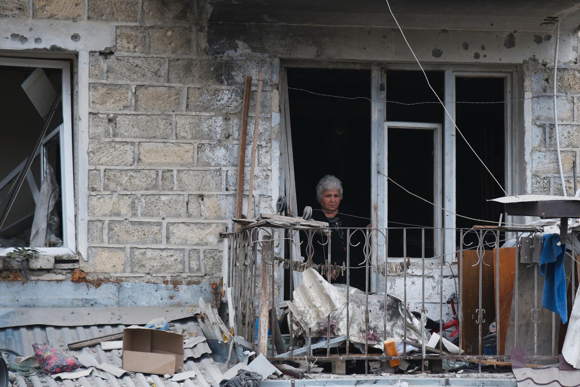 En kvinna ser över skadorna i en bostad i Stepanakert, i söndags för en vecka sedan.