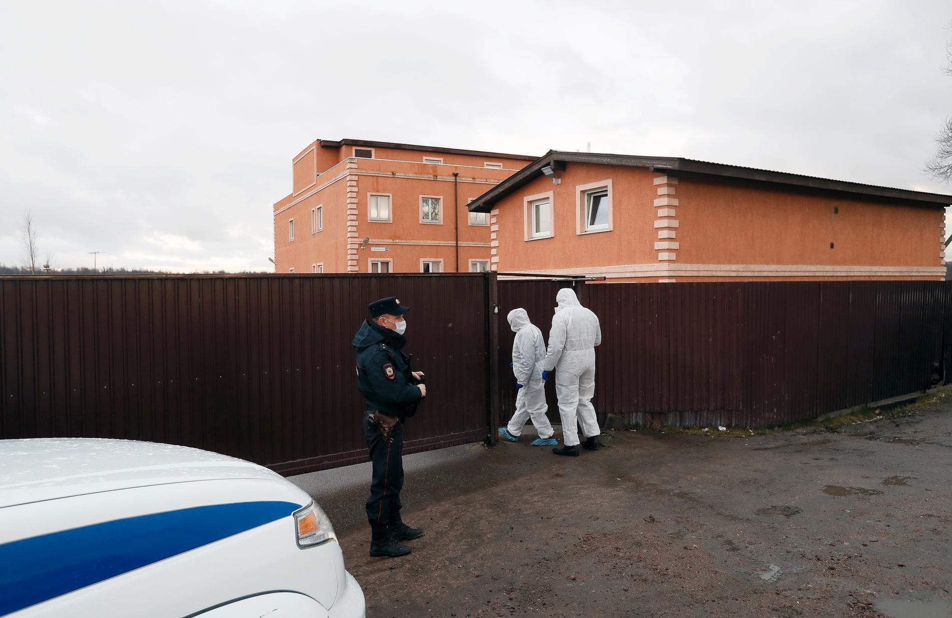 Medicinsk personal i skyddsdräkter går in i boendet för de sjuka Ikea-byggarna i Leningradregionen i Ryssland.