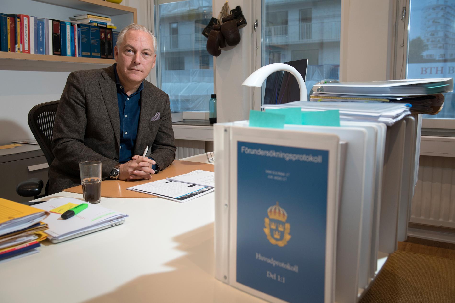 Rakhmat Akilovs försvarsadvokat Johan Eriksson sitter vid sitt skrivbord med den omfattande förundersökningen i förgrunden.
