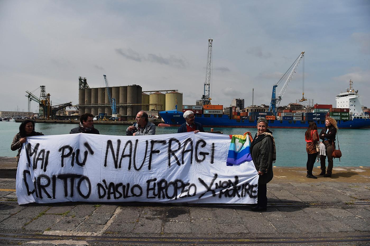 Demonstranter i hamnen håller en banderoll med texten ”Inga fler skeppsbrott, europeiska rättigheter till asyl för att undvika framtida dödsfall”.