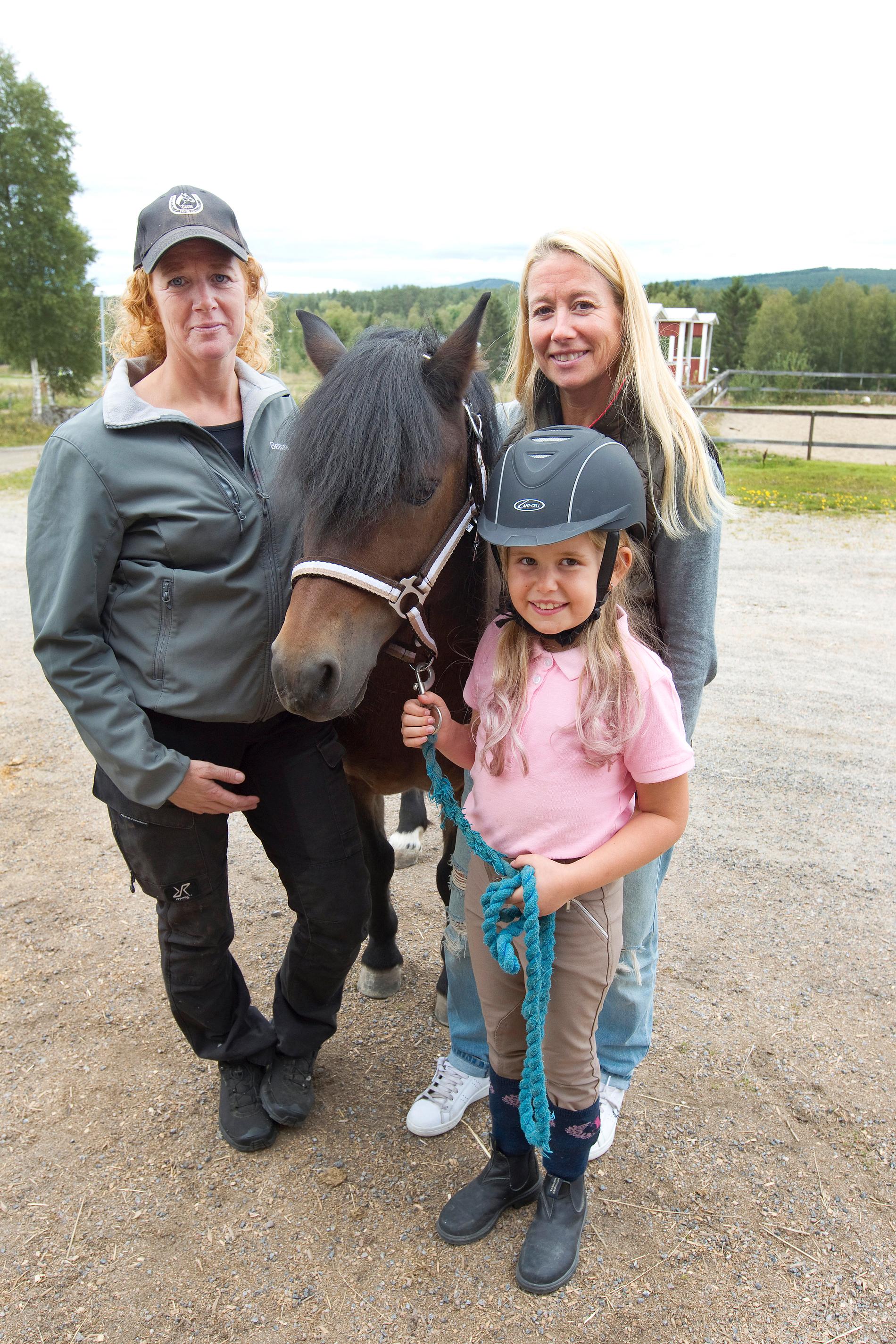 Både mamma Katharina Olsson (till höger) och ridläraren Bettan Lindborg (till vänster) ser hur mycket Storm betyder för Stinas utveckling. 