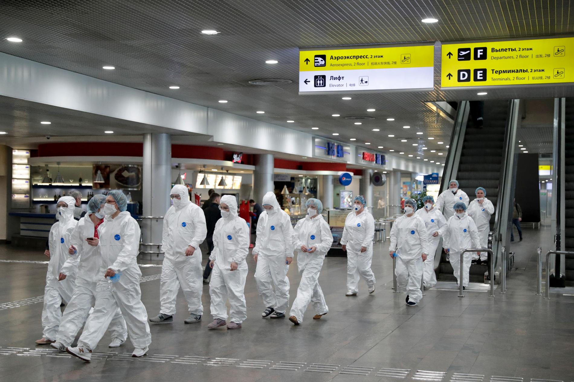Ryska vårdarbetare på väg för att kontrollera resenärer som anlänt från utlandet vid Sjeremetevos internationella flygplats utanför Moskva i förra veckan.