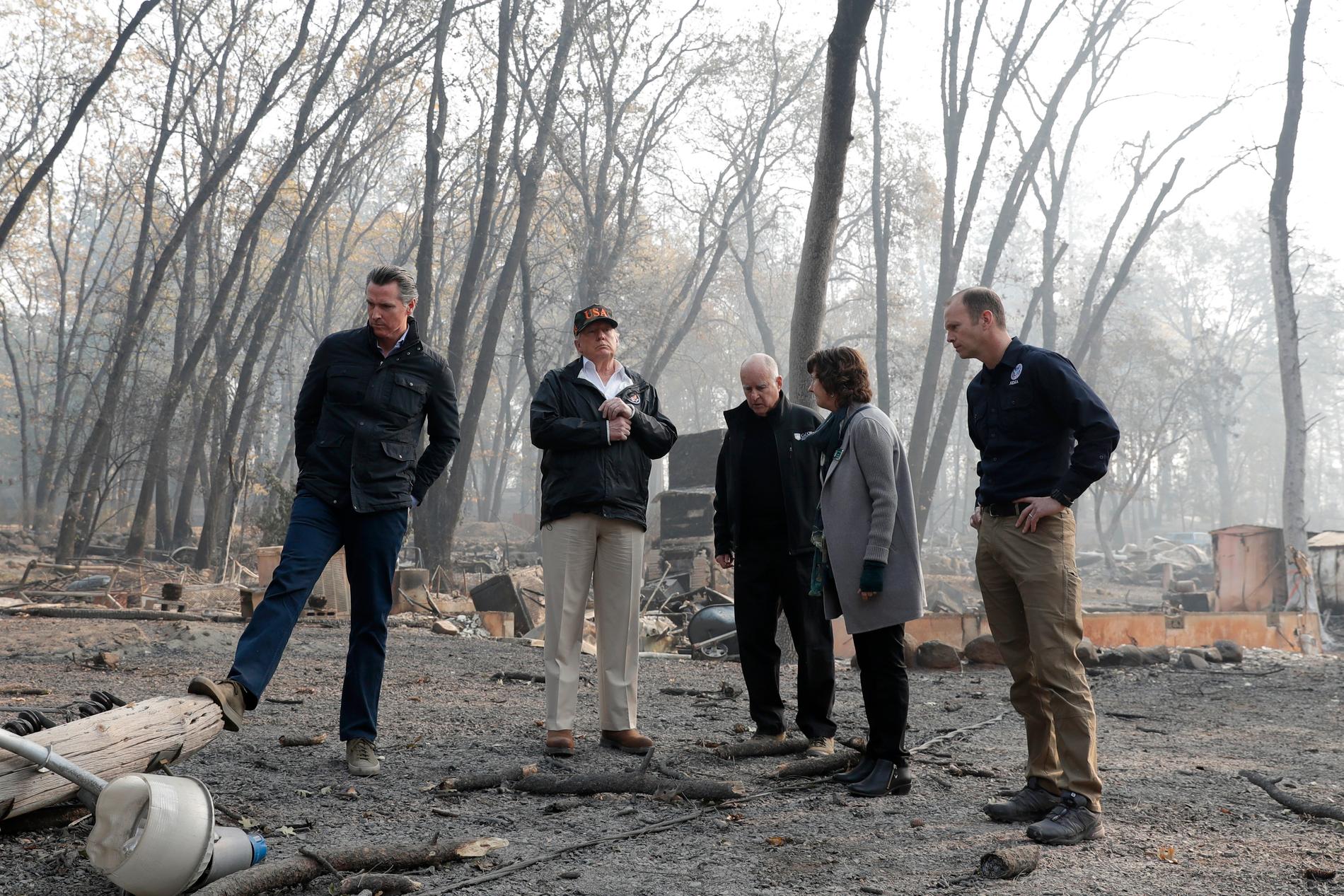 President Donald Trump besöker brandhärjade områden. På bilden syns bland andra Kaliforniens guvernör Jerry Brown.