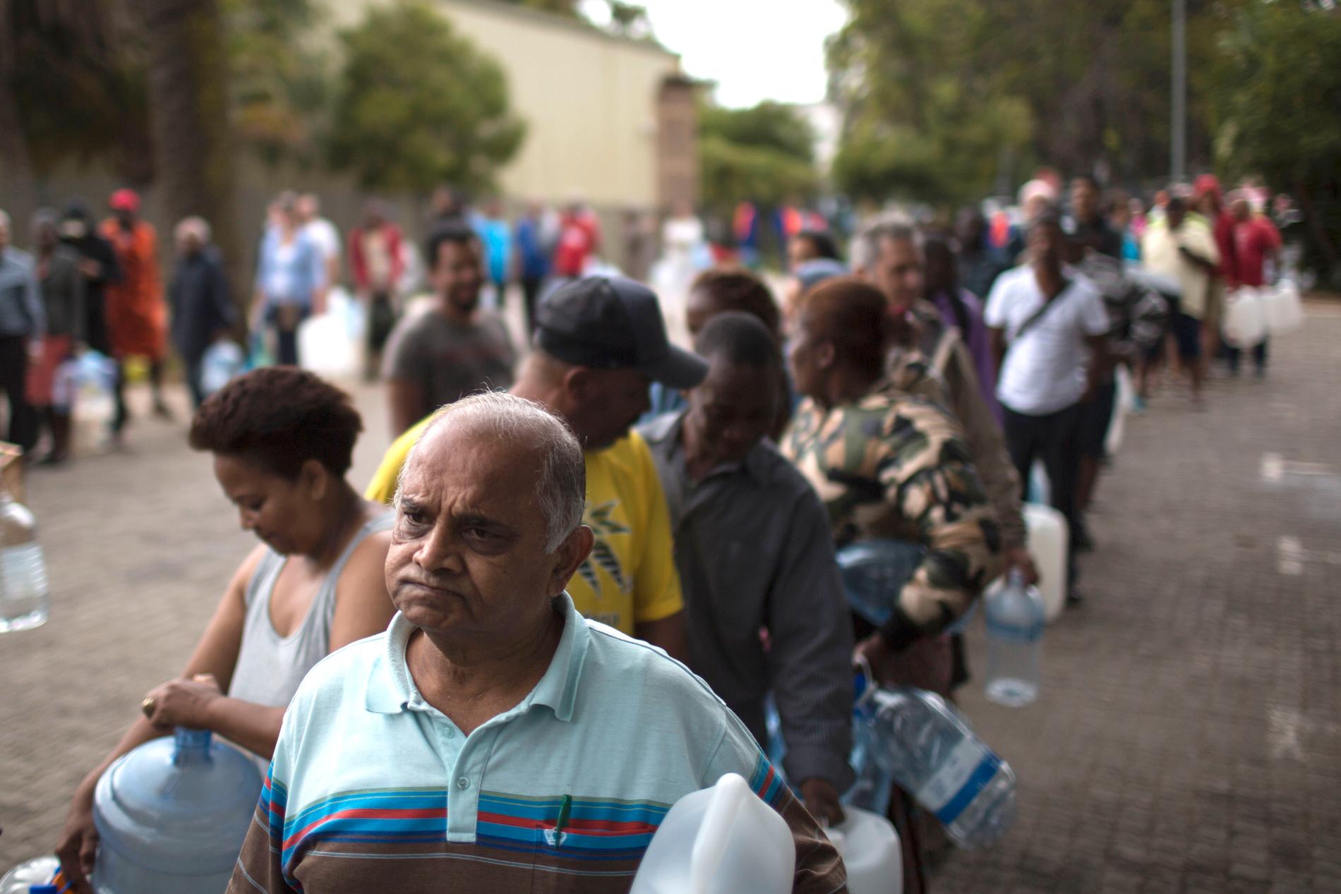 Människor i Kapstaden köar för att hämta vatten.