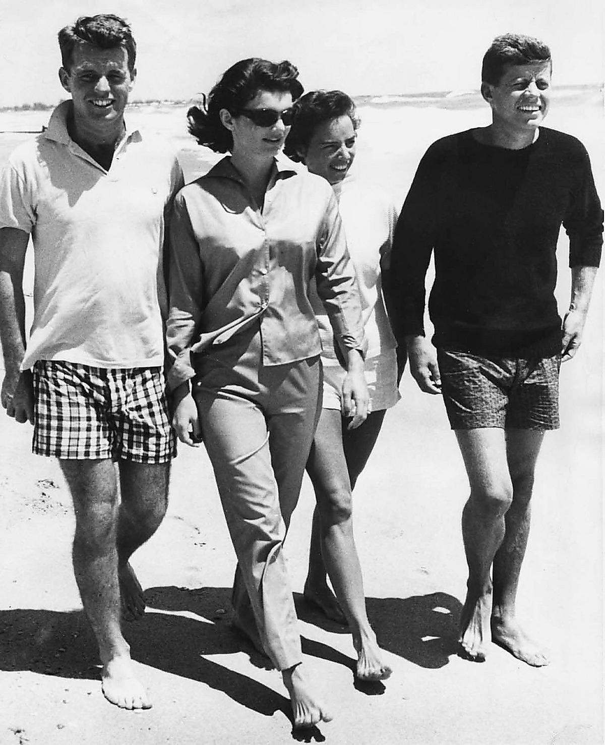 På väg mot makten – och myten Robert och John F Kennedy på strandpromenad med fruarna Jackie och Ethel 1957. Fyra år senare satt de båda bröderna vid maktens roder.